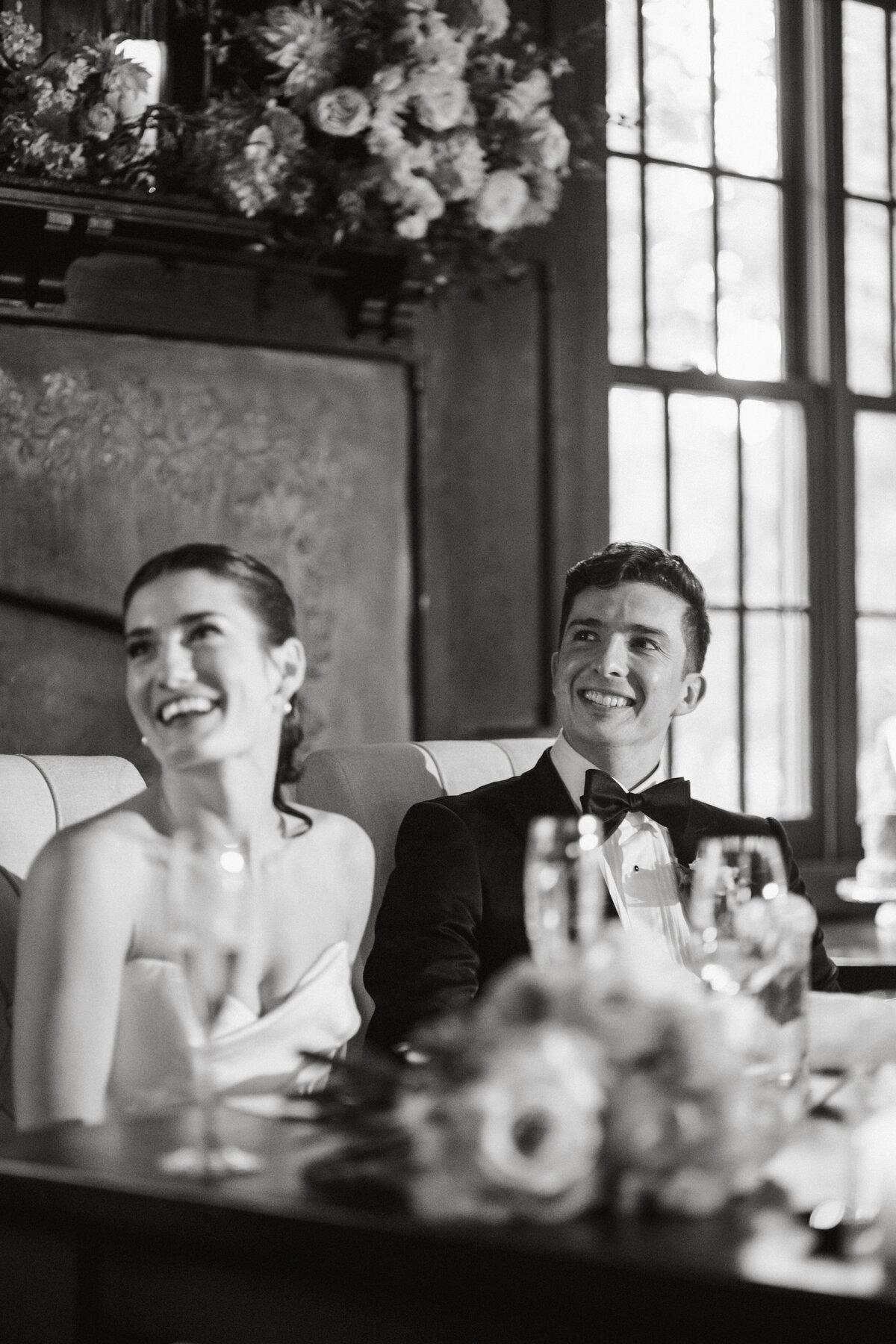 Bride and groom laughing at the dinner table