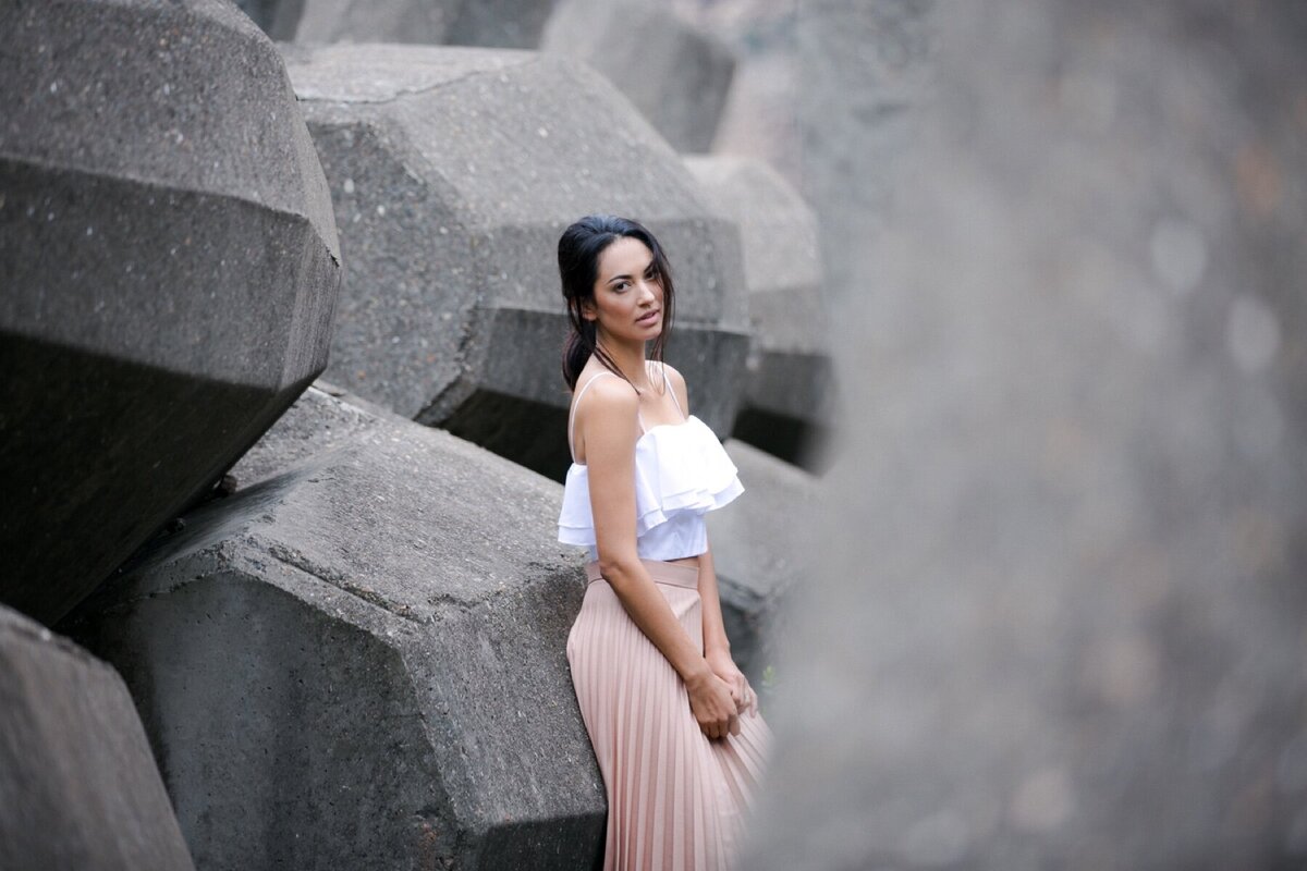 Picture of woman in pink skirt and white top amongst cement boulders