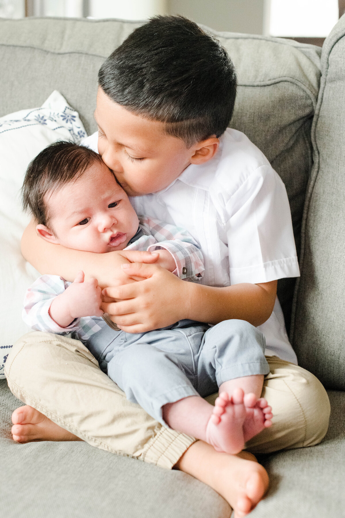 big brother kissing baby brother cheek