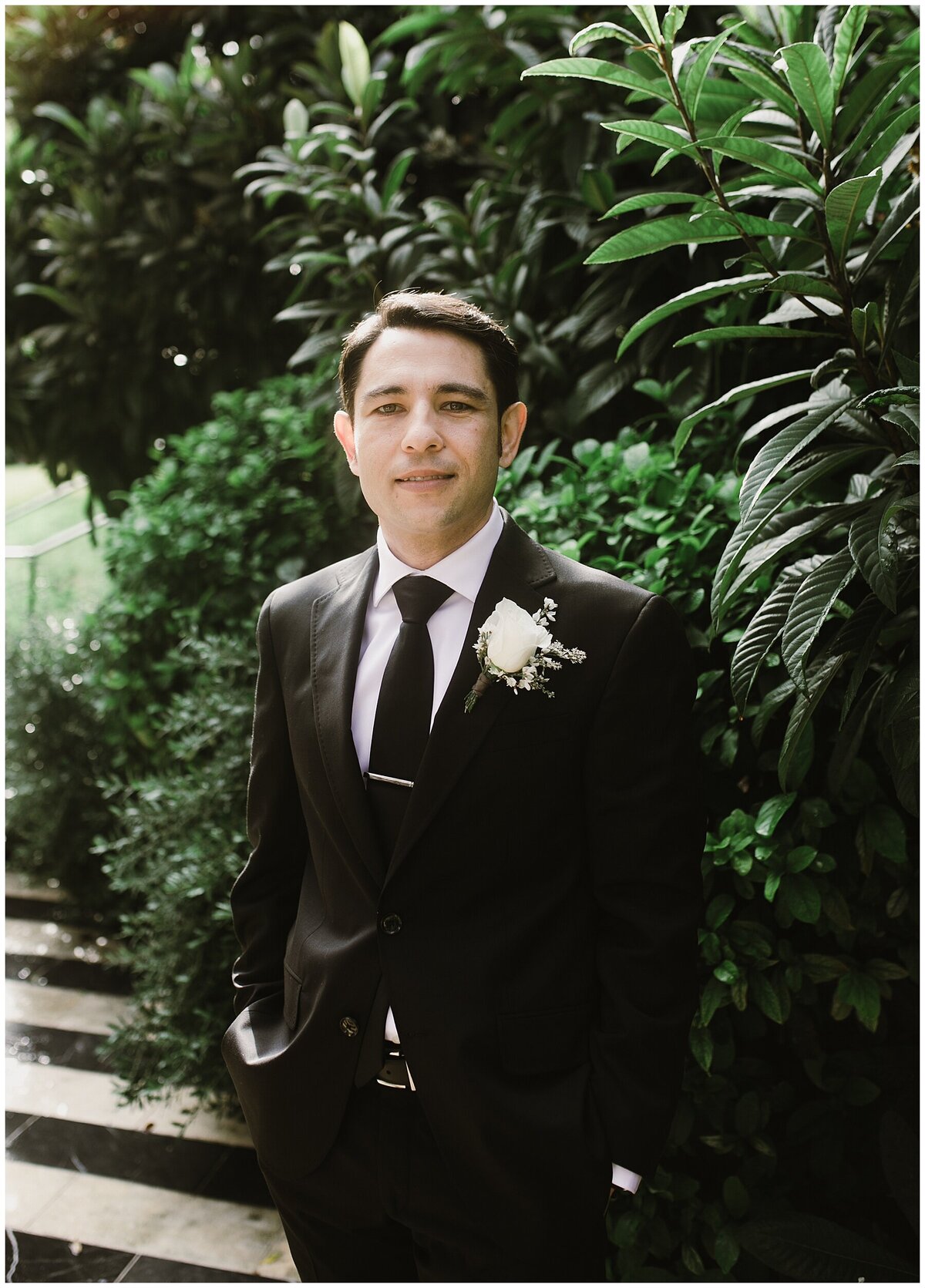 Groom wearing black suit  in the grounds of Hotel Cecilia Austin