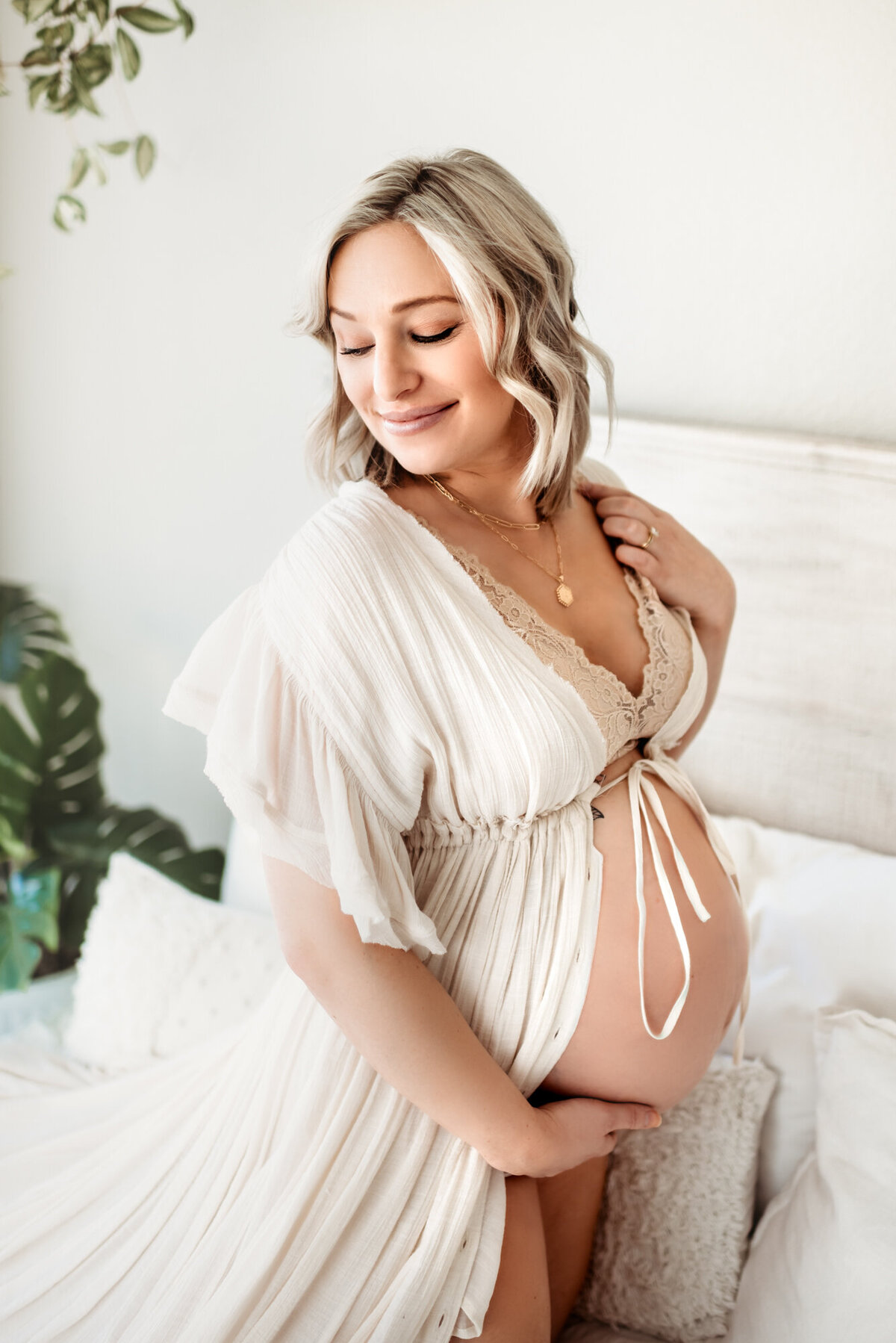 pregnant woman holding bare belly looking over her shoulder