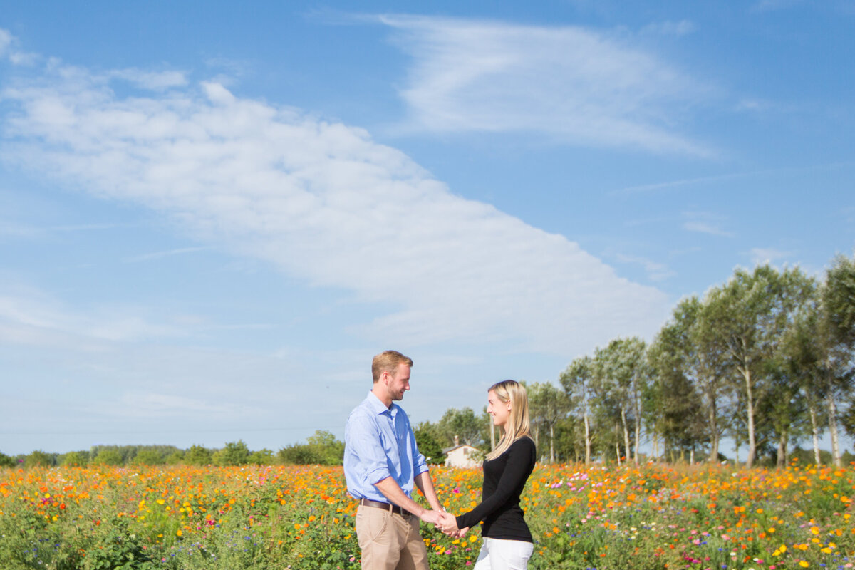 Couple holding hands in flower field