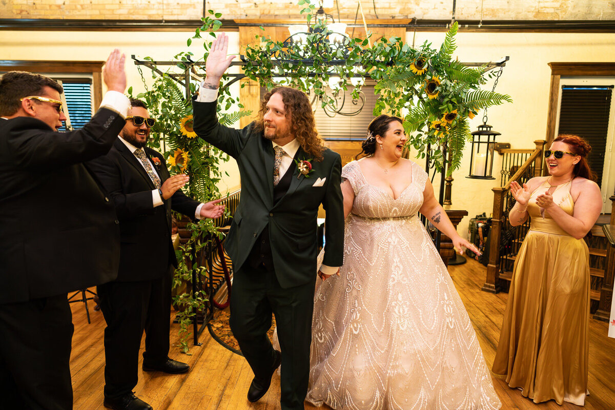 Bride and groom high five guests when entering reception at Kellarman's Event Center.