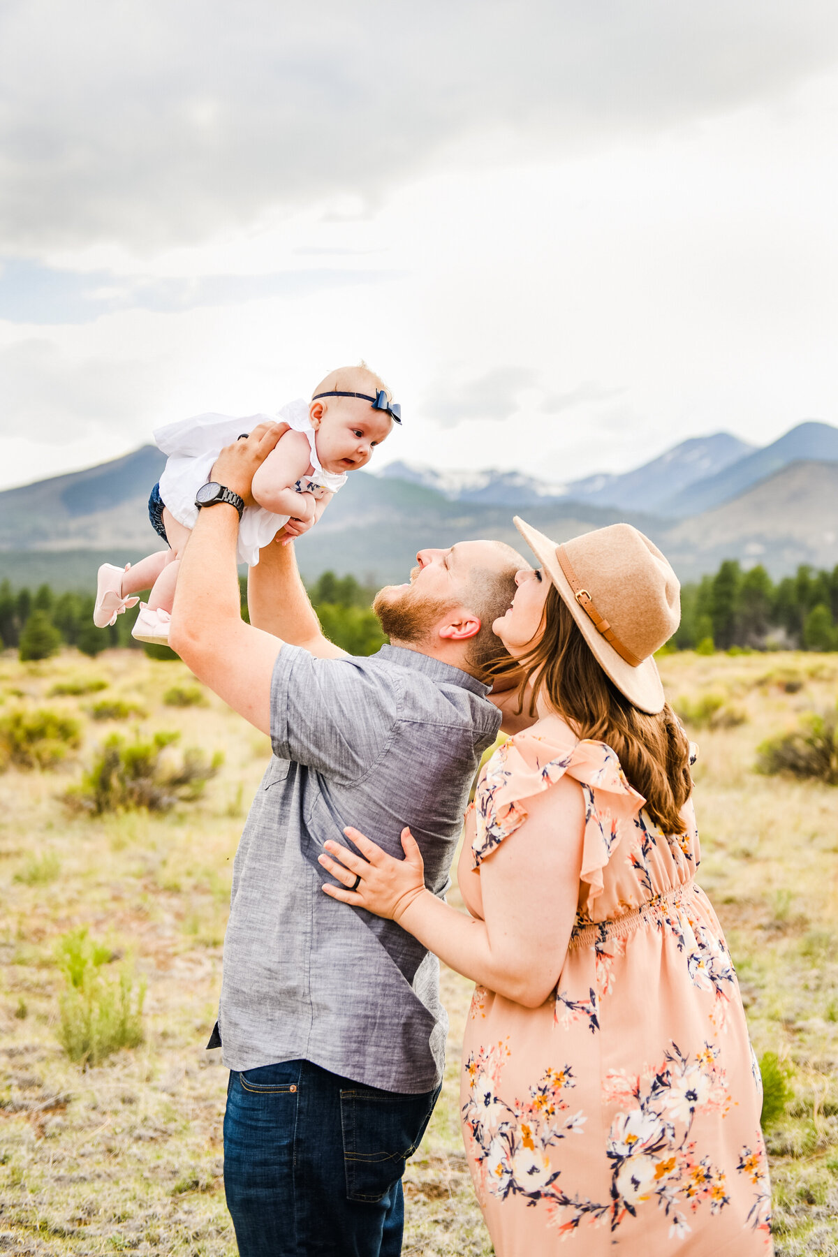 Parents holding up baby Flagstaff family photography mountains spring