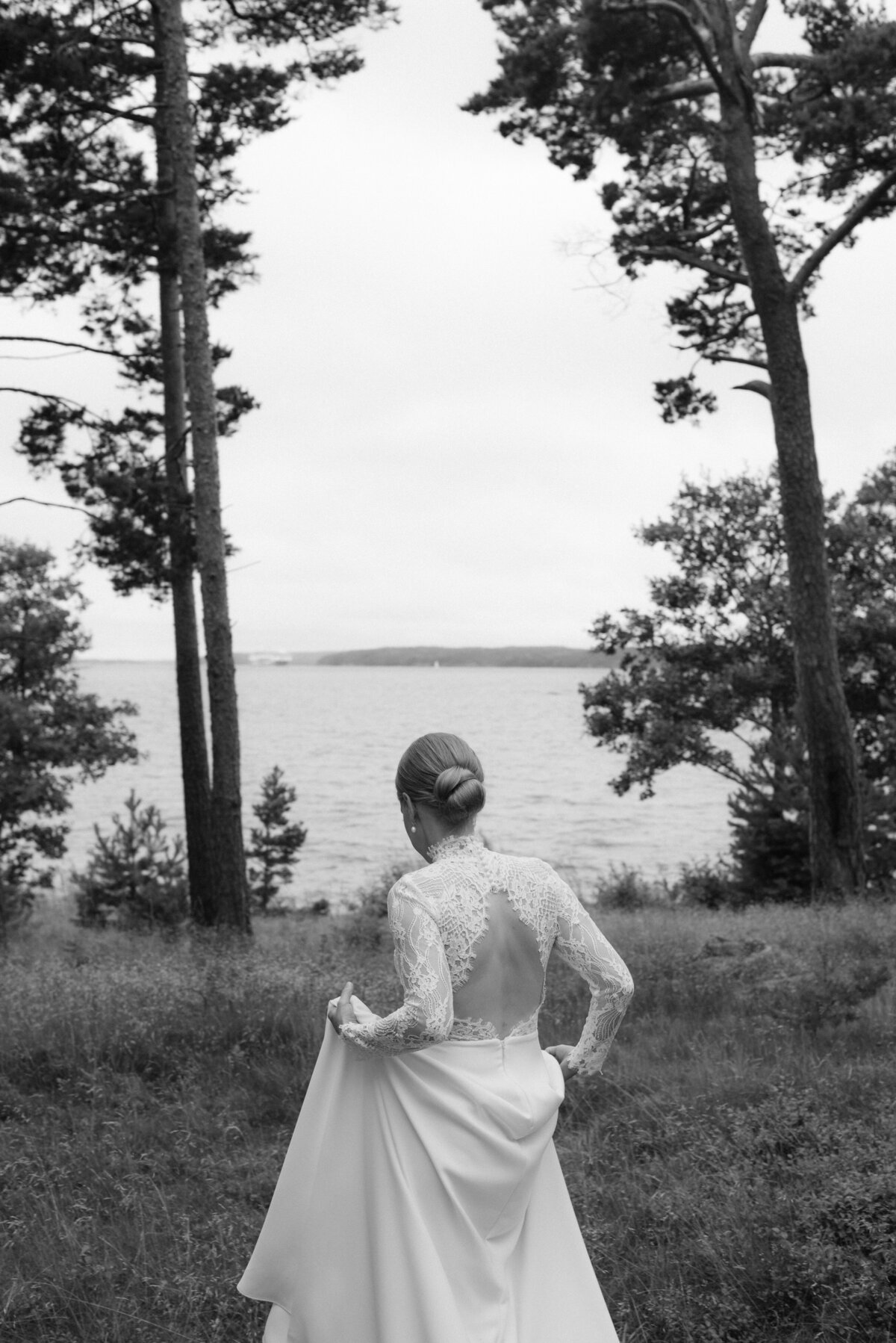 The bride outside the wedding venue Airisniemen kartano. The sea is on the background. An image by wedding photographer Hannika Gabrielsson.