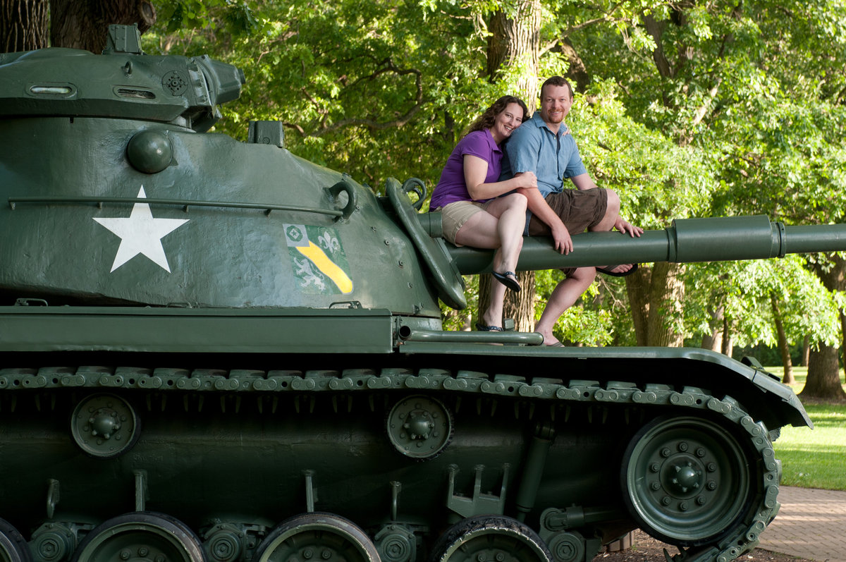 An engagement couple pose atop a tank at cantigny park