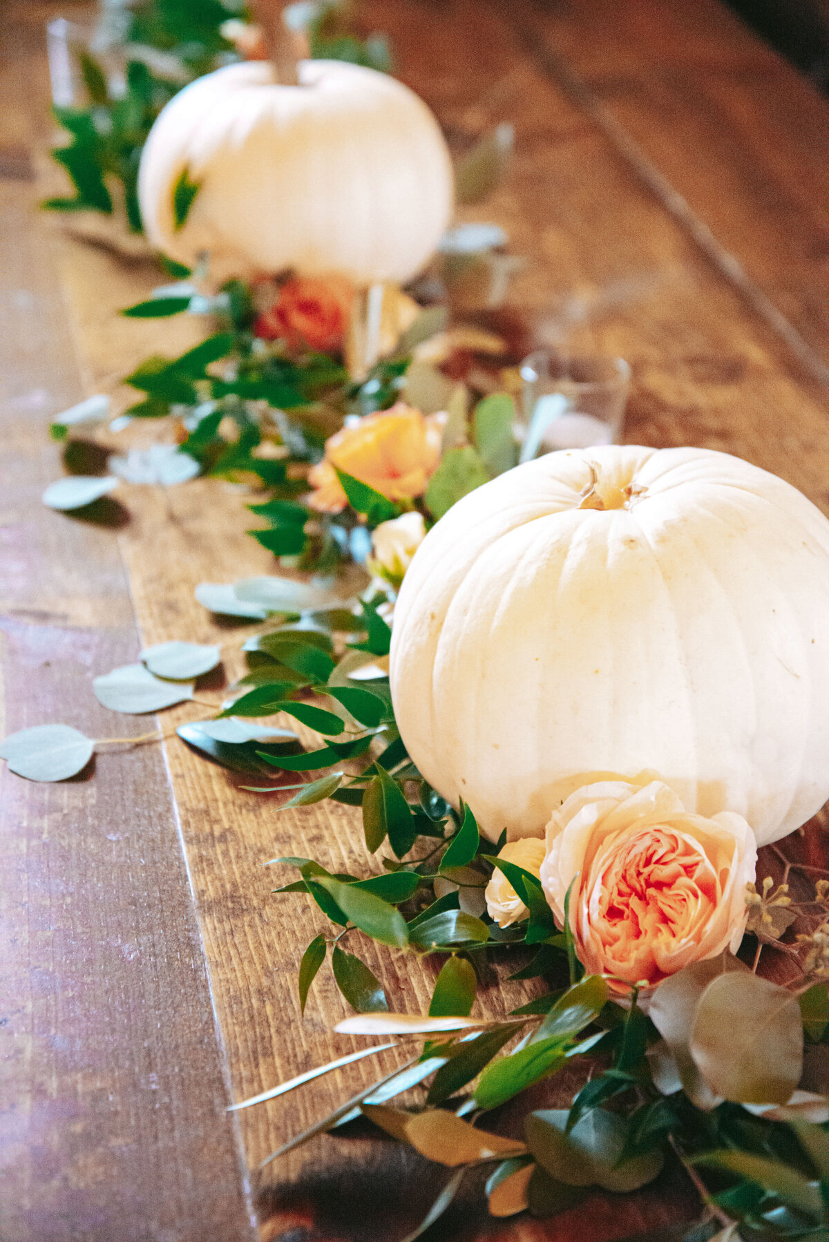 Farm table loose greenery, flowers in peach  with small white pumpkins