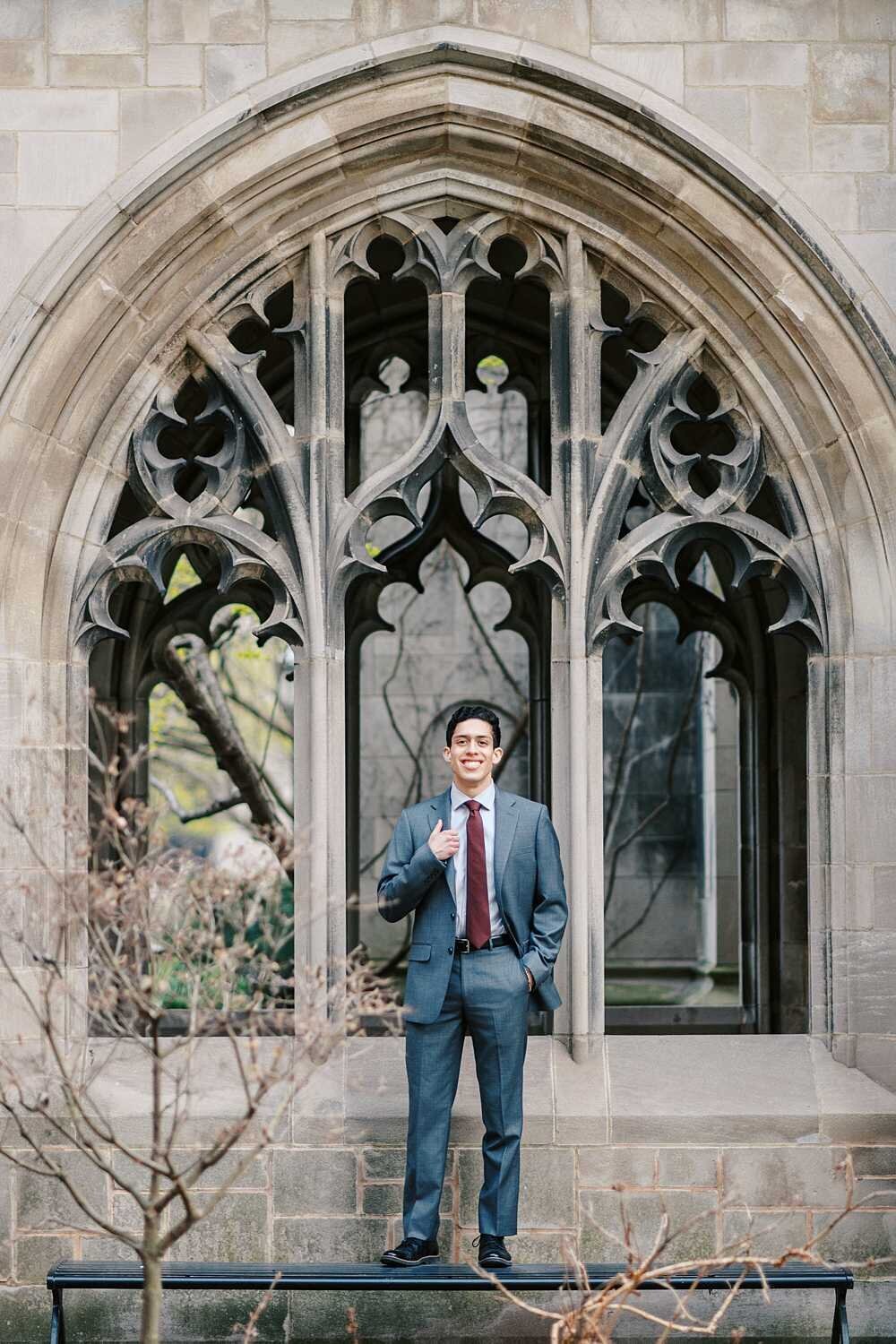 Male senior picture of a university senior wearing a gray suit at the University of Chicago's Bond Chapel
