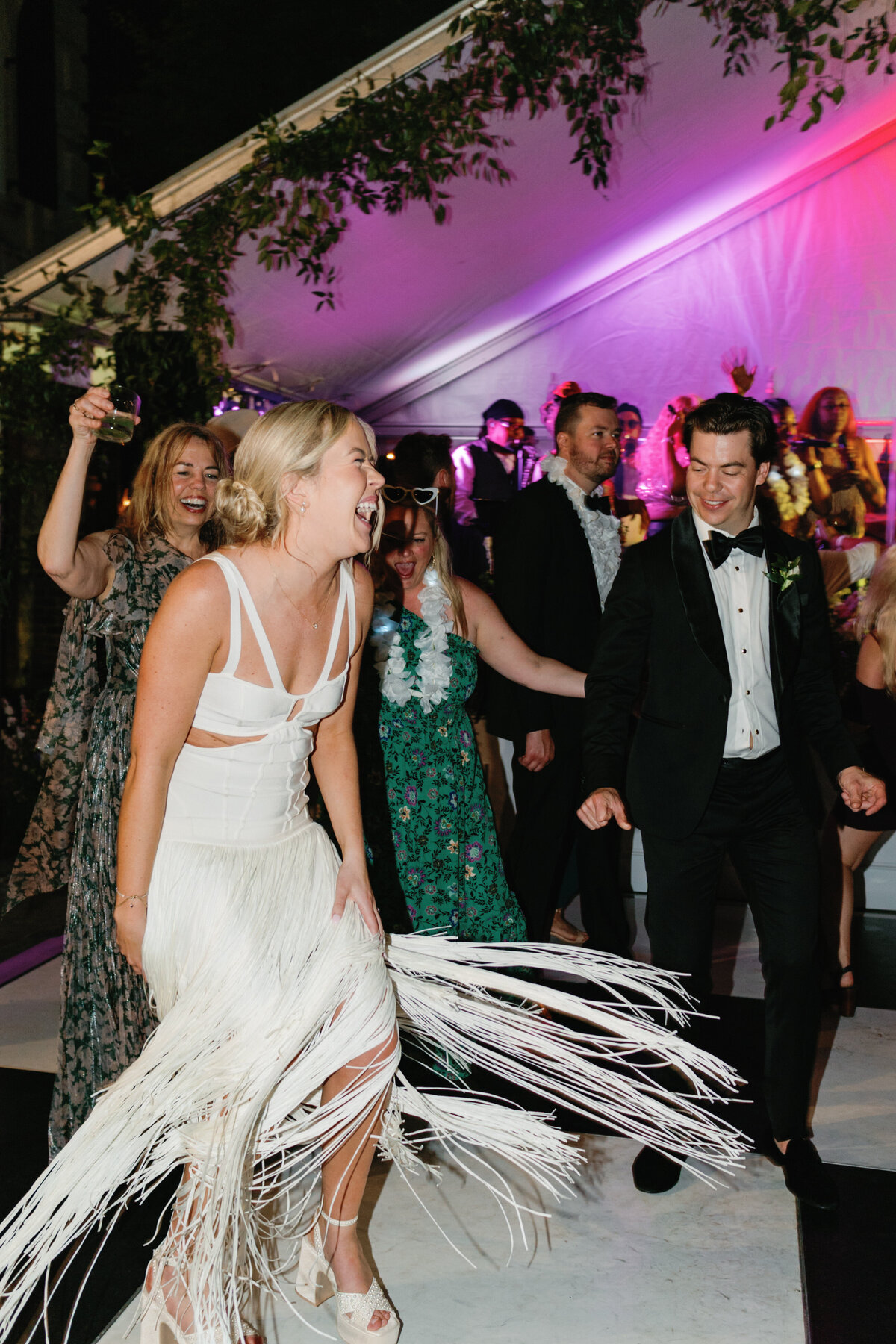 Bride twirls in fringe Herve Leger dress. Bride second outfit reveal on the dance floor. Spring wedding with live band at William Aiken House. Fun wedding reception photographer. Kailee DiMeglio Photography.