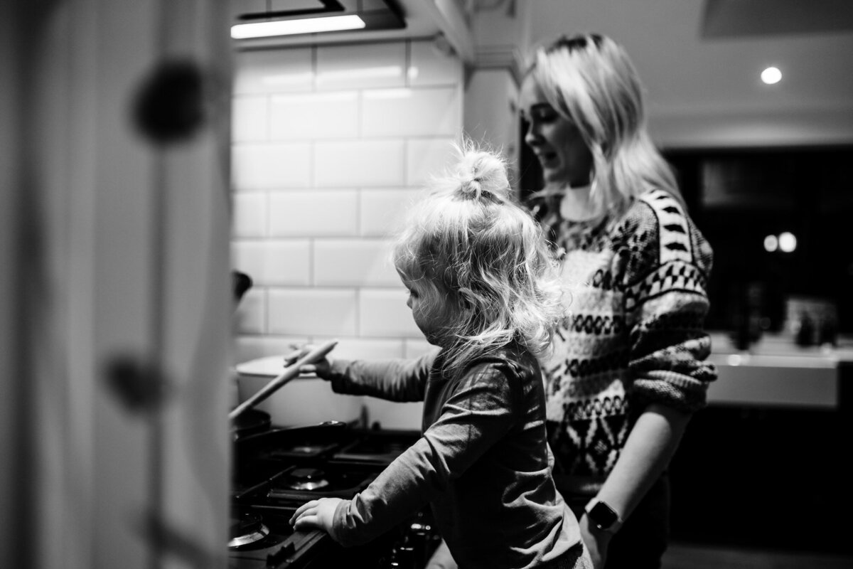 Daughter helping her mum cook dinner at home family photoshoot