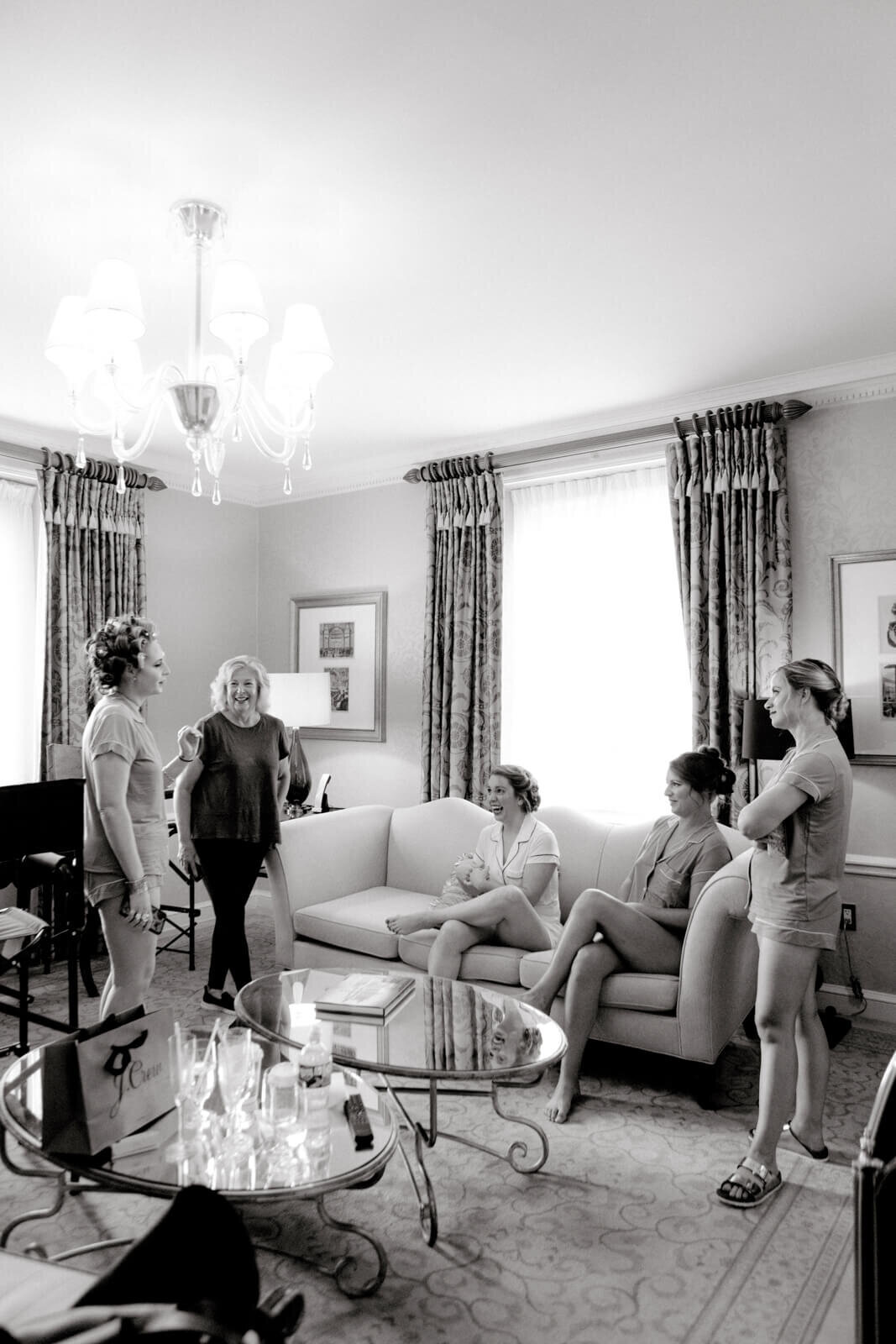 A group of five ladies inside a room, chatting happily