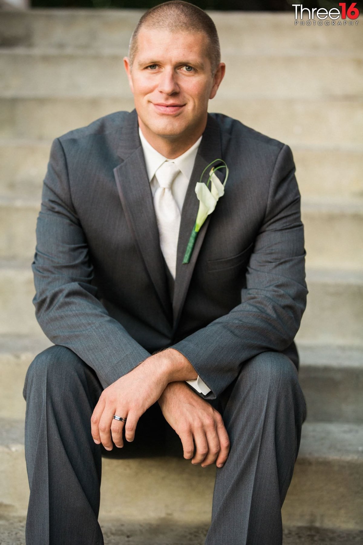 Groom sitting as he poses for the photographer