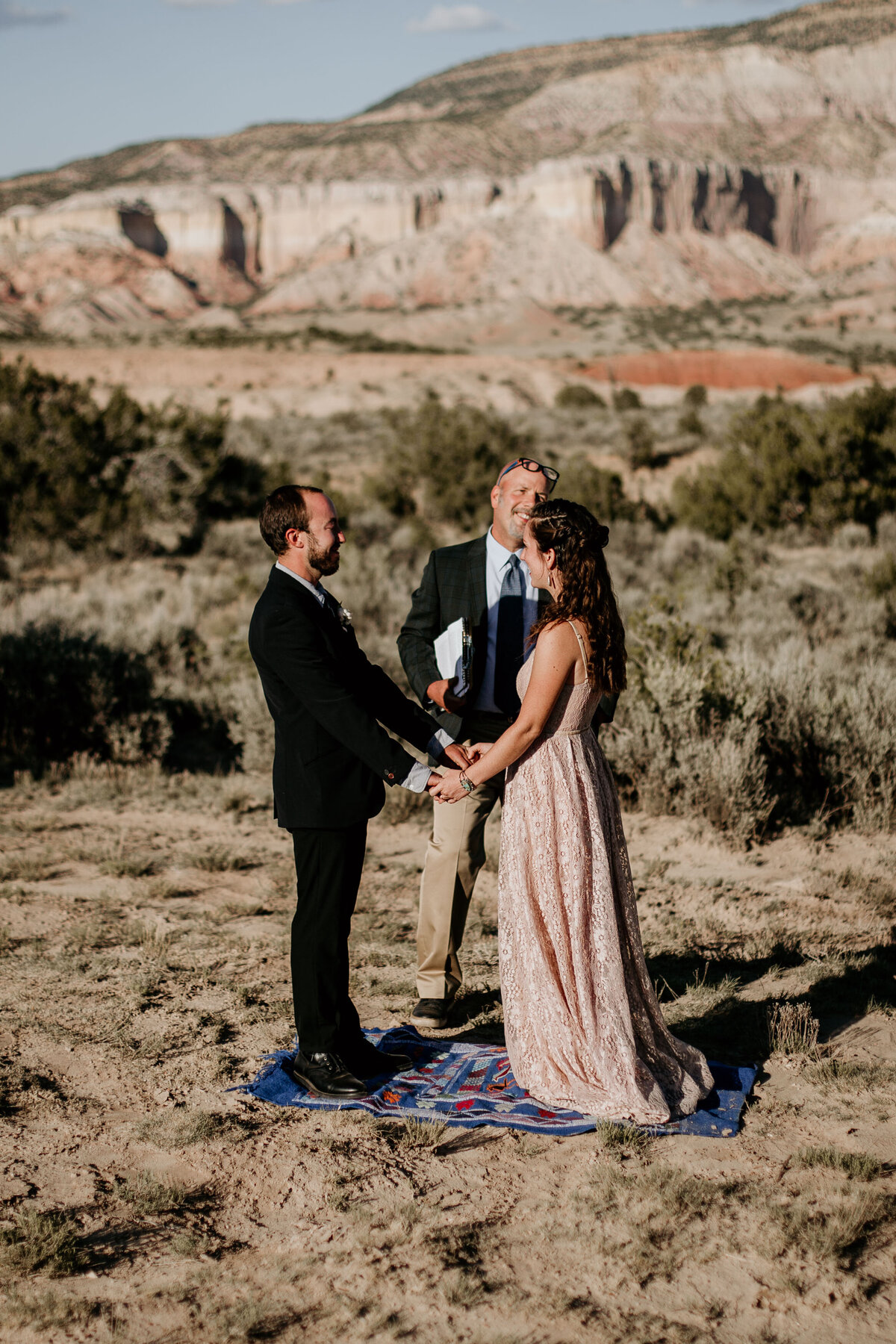 bride and groom holding hands at desert ceremony