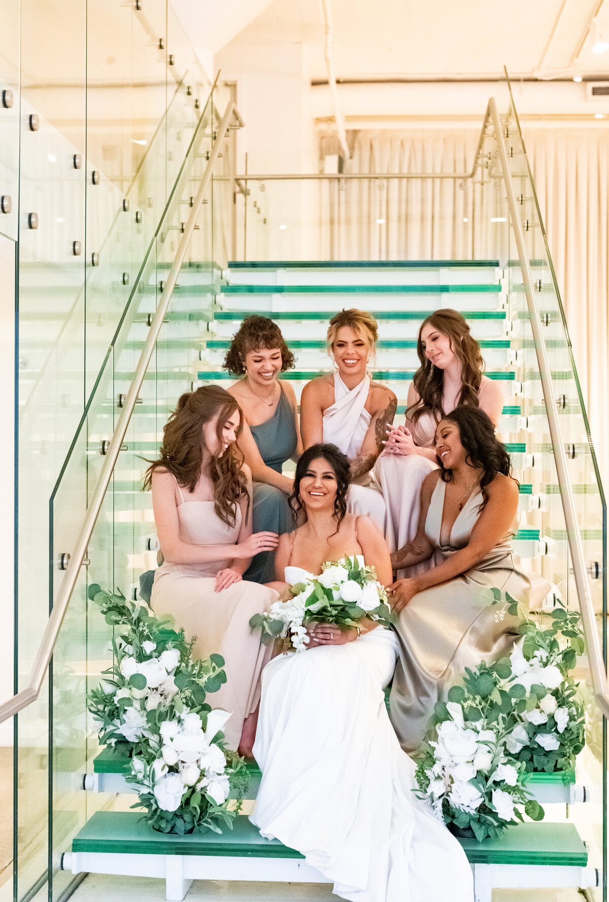 Bridal party surrounding bride sitting on stairs