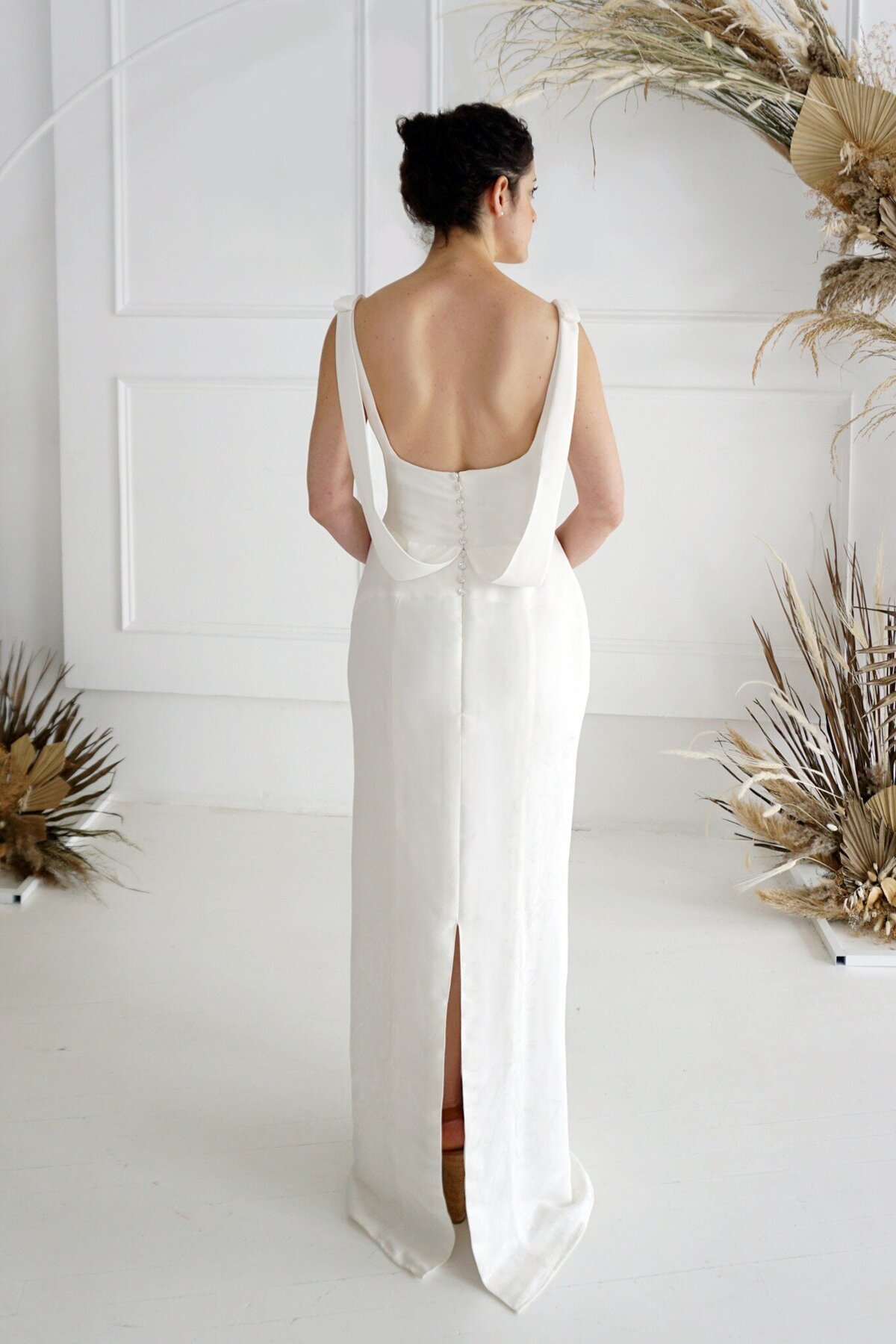 The back of the Jealine wedding dress style with the detachable trains removed showcases  the column silhouette of the skirt.