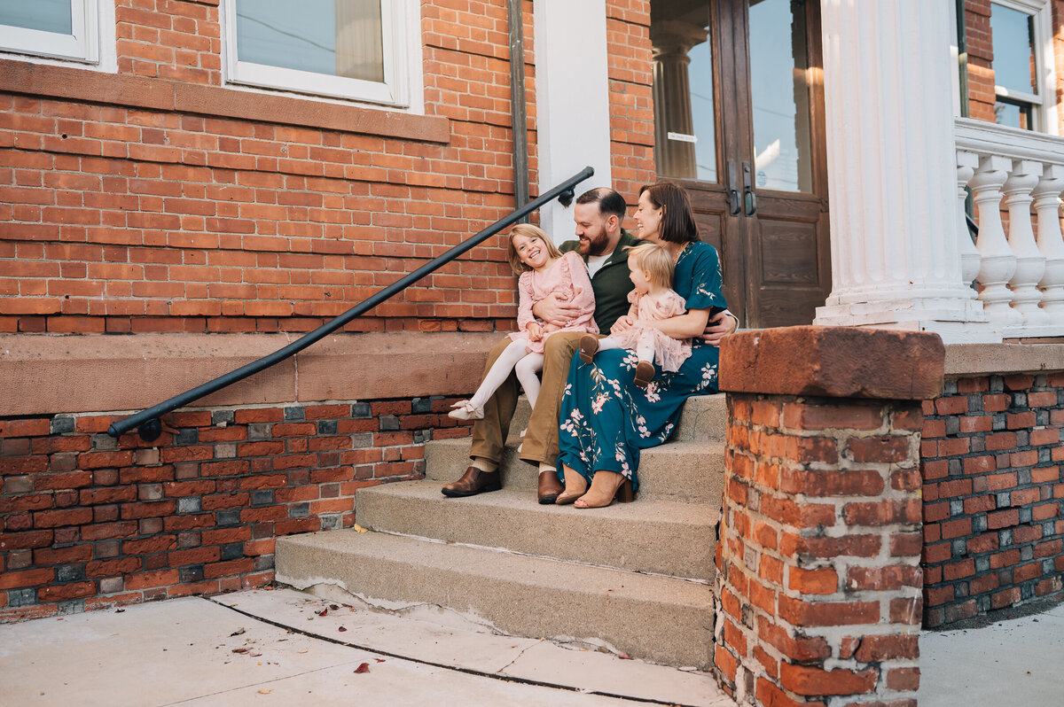 A family of four playing with one another at their outdoor family photo shoot in Canton, Connecticut.