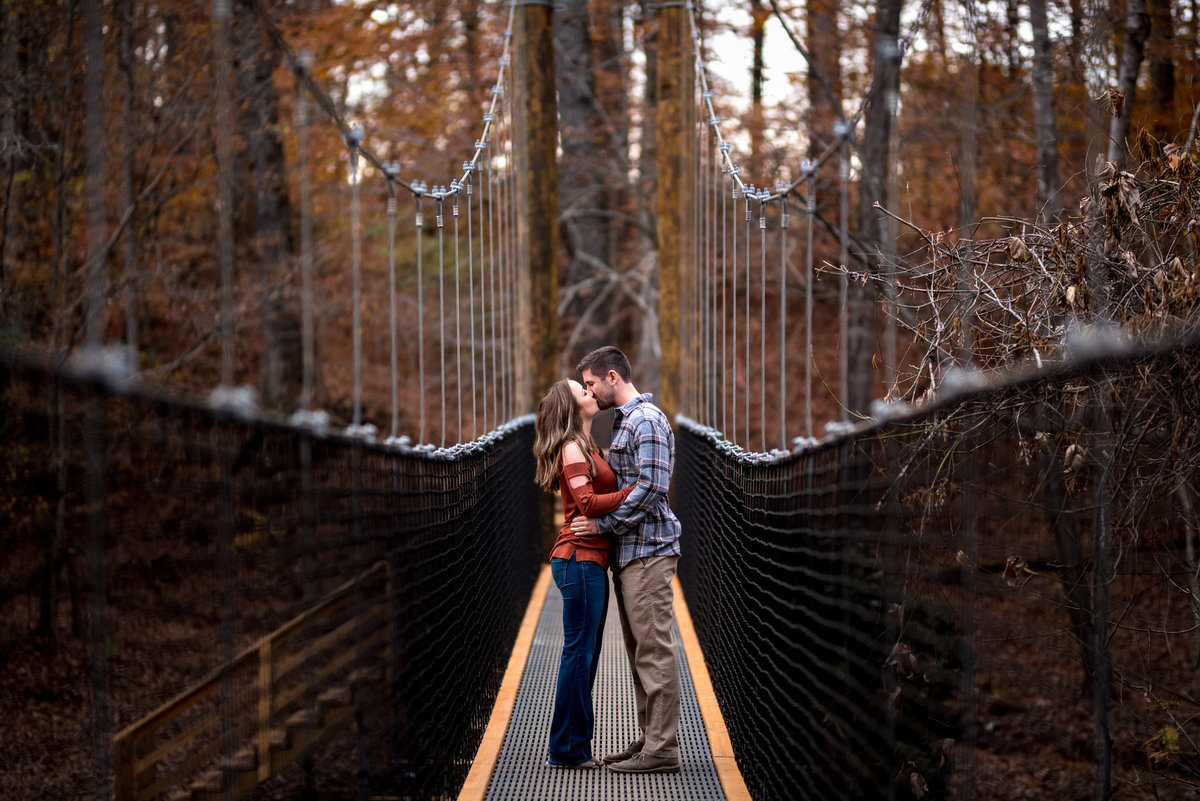 engaged-couple-kiss-on-bridge