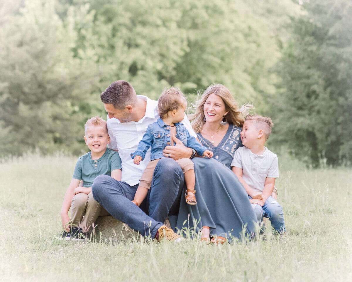 outdoor family session with a beautiful familu of 5 all sitting and laughing