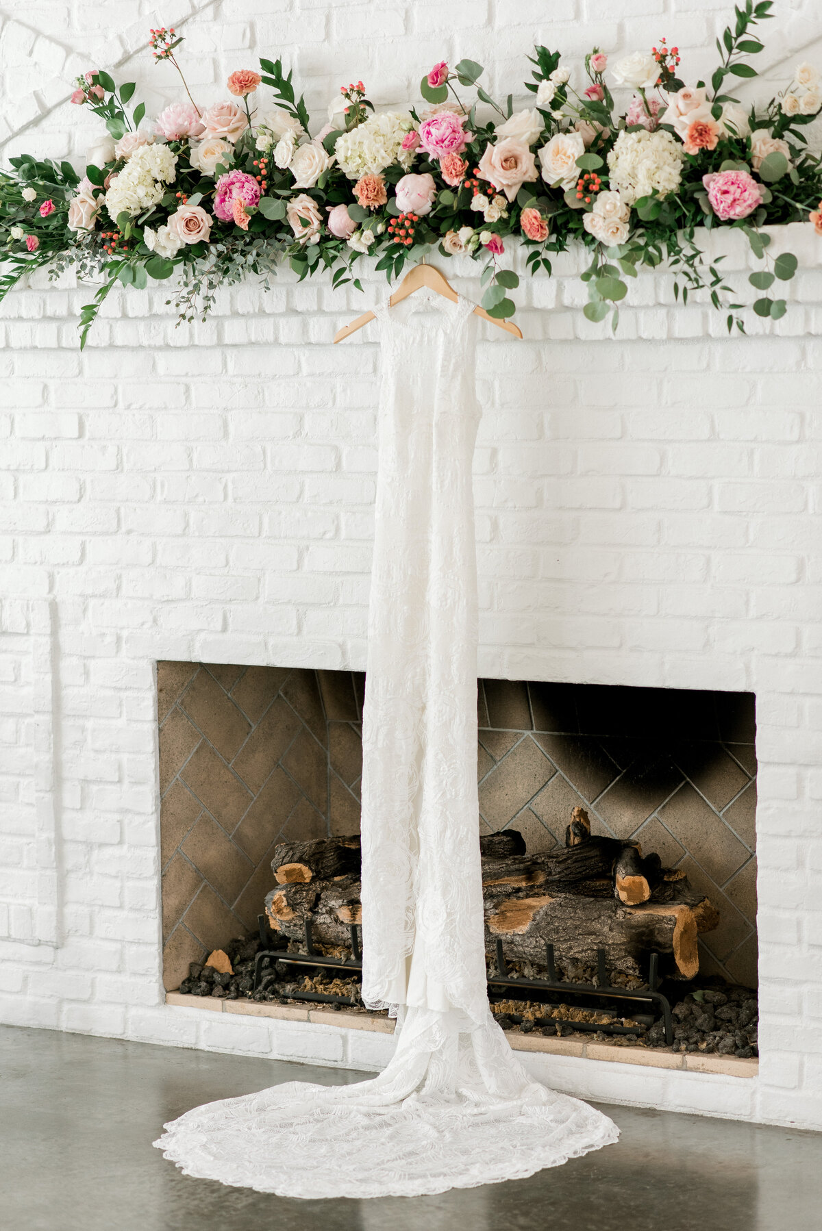 wedding dress hanging by a fireplace