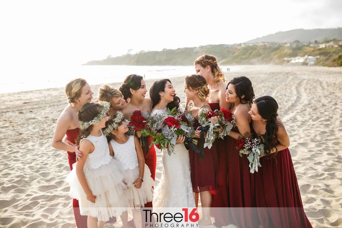 Bride and Bridesmaids share a laugh on the beach in Dana Point