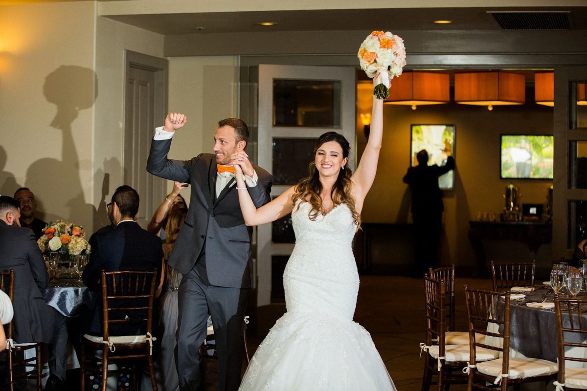 Bride and Groom enter the reception room with arms in the air