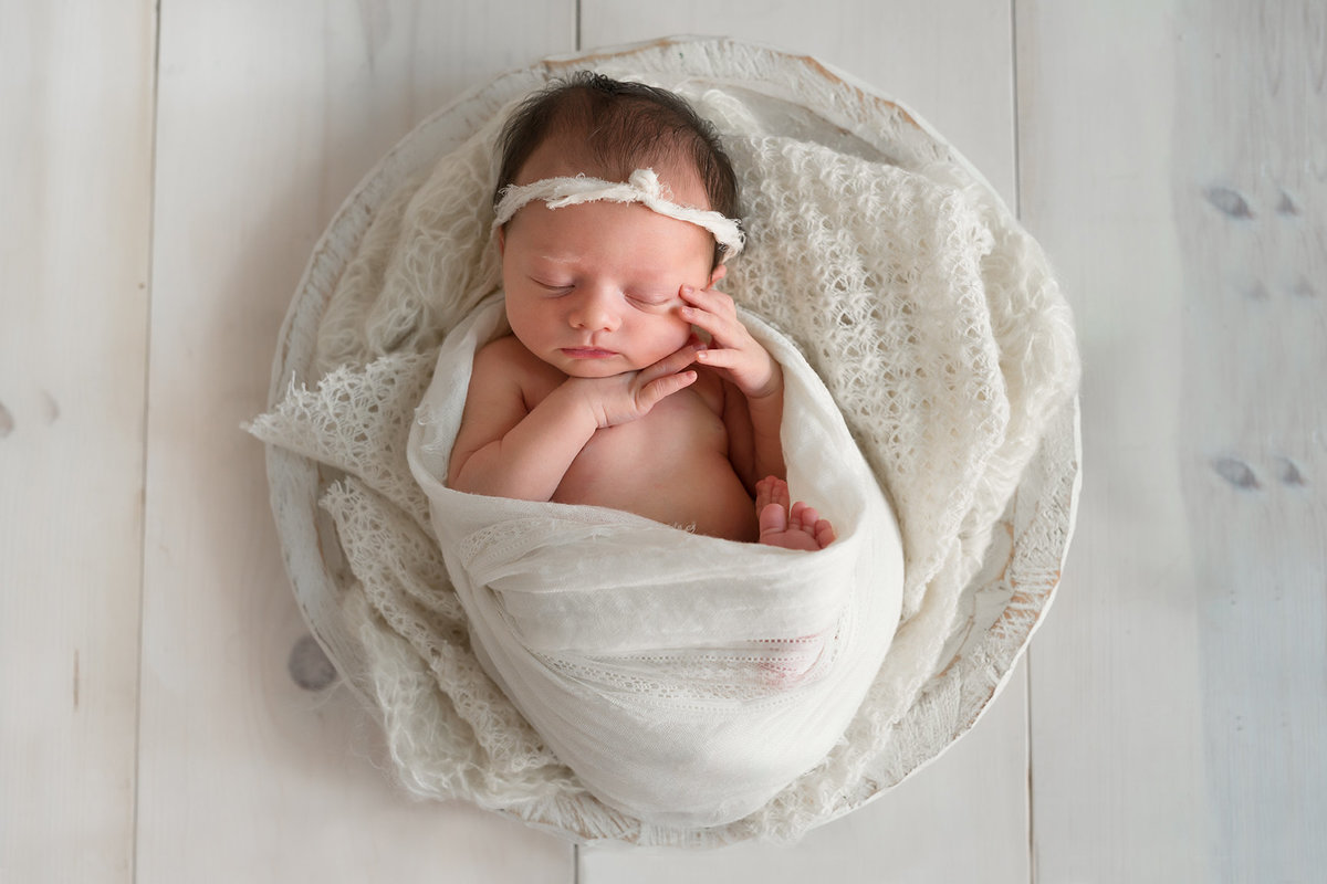 newborn girl wrapped in white