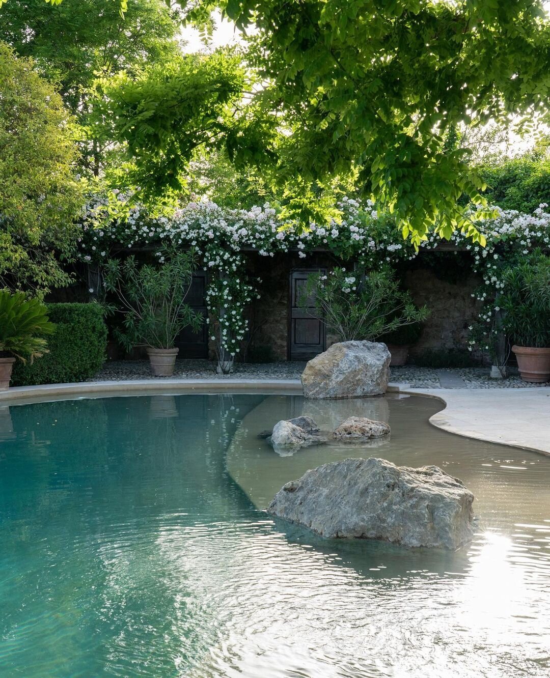 A lagoon style pool with jasmine covered trellises at Borgo Santo Pietro