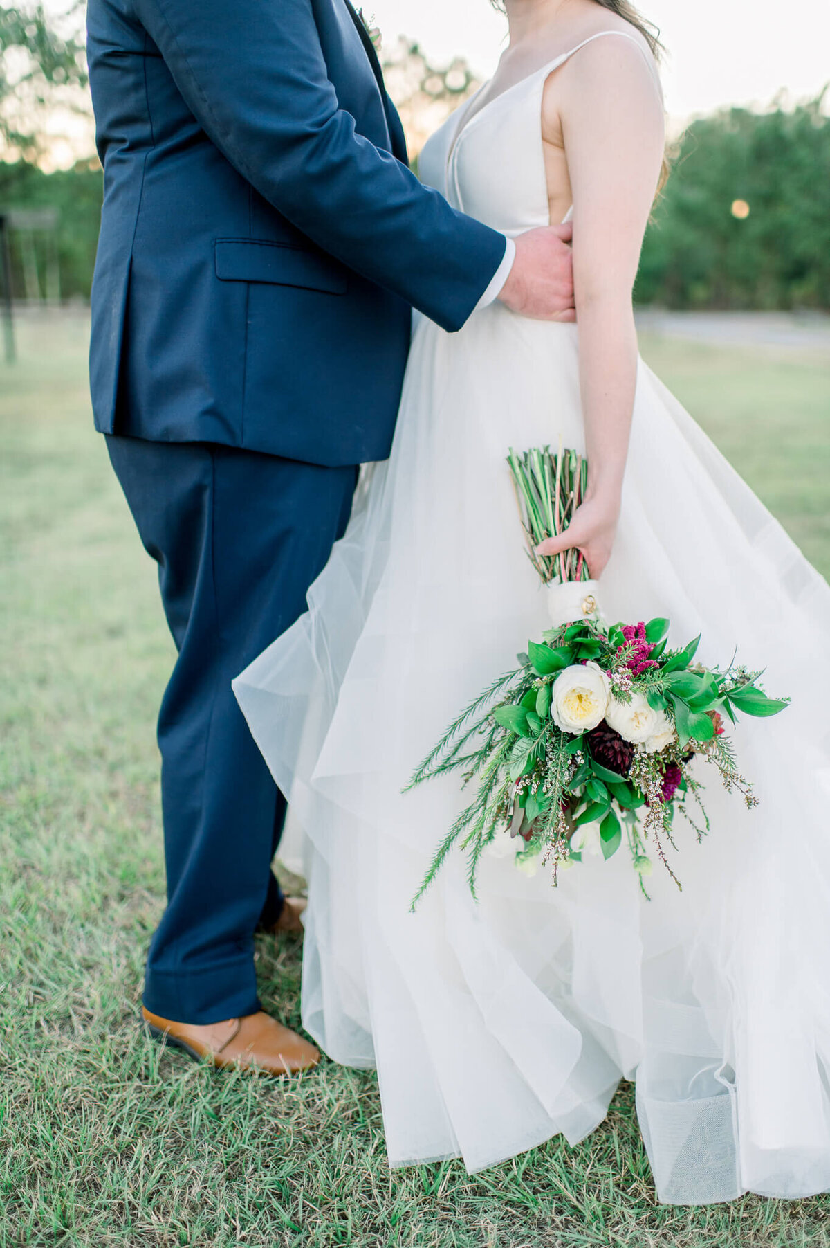 close up photograph of bride and grooms legs and wedding bouquet by arkansas photographer