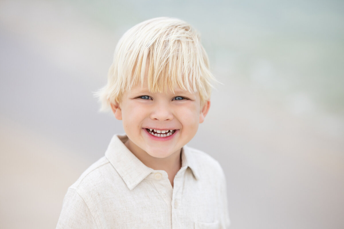 A small boy smiling big.