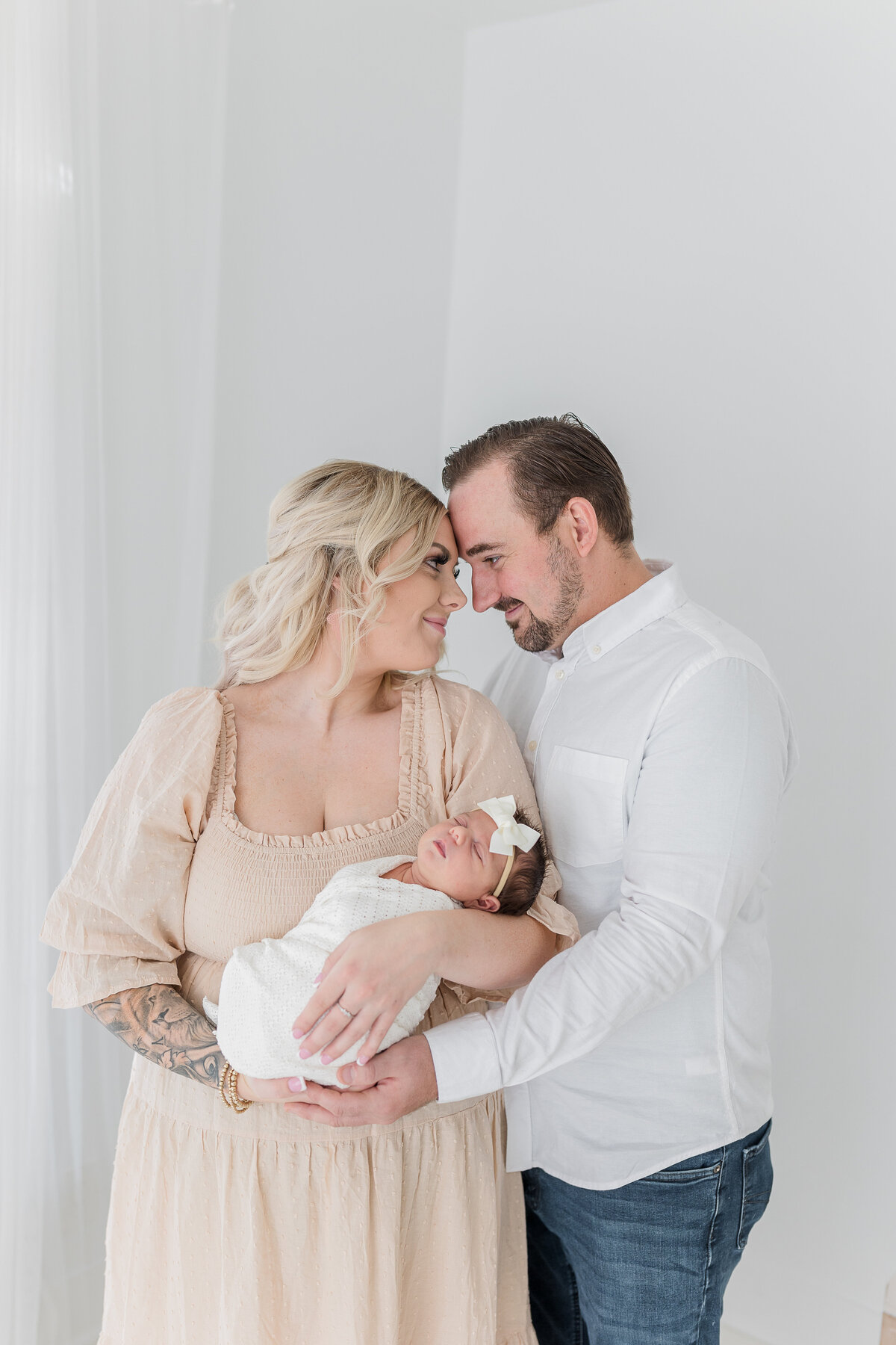 A gorgeous couple hugging in studio in Folsom enjoying their maternity photoshoot by Caroline Bendel