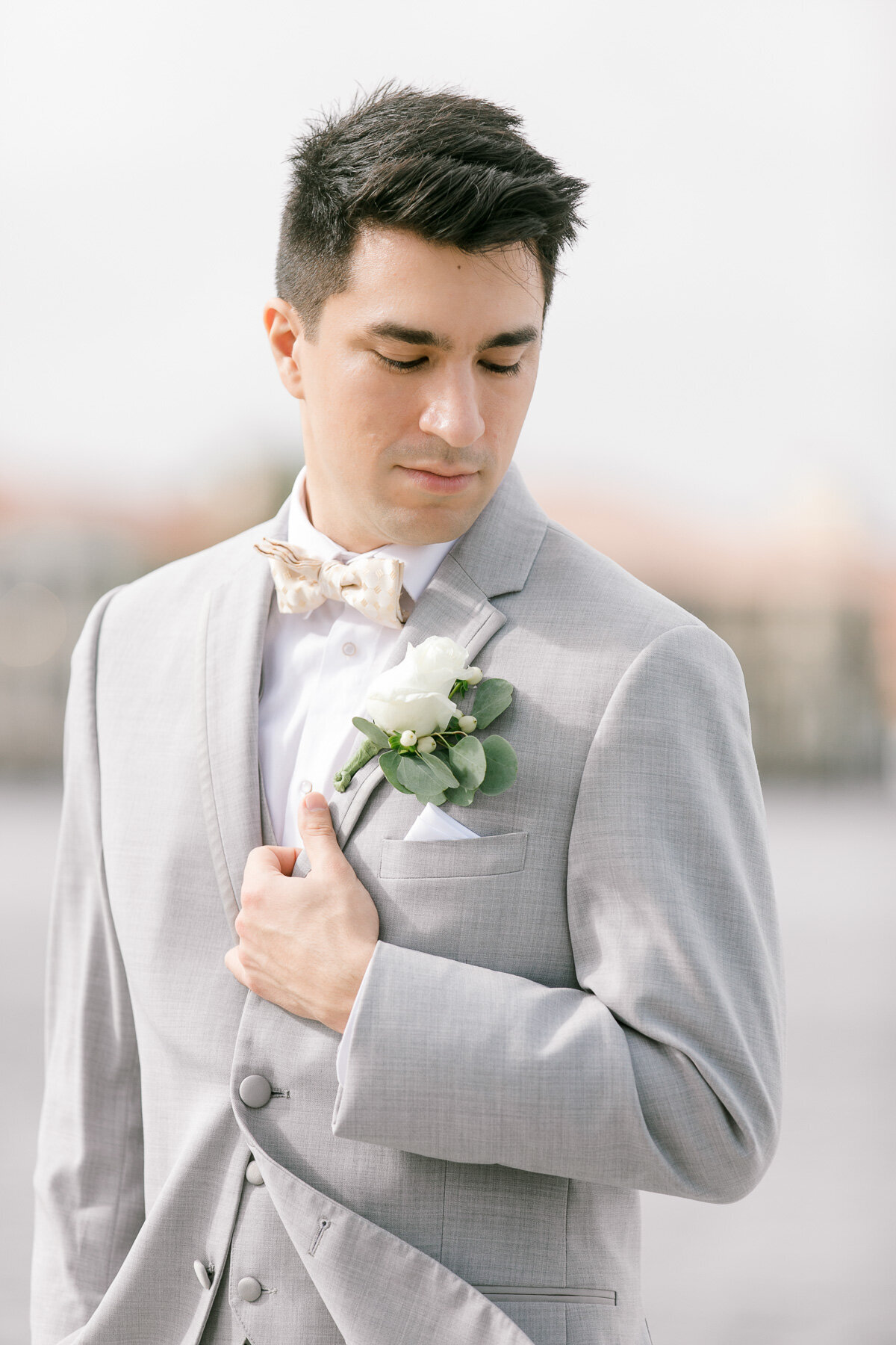 groom looking at boutonniere
