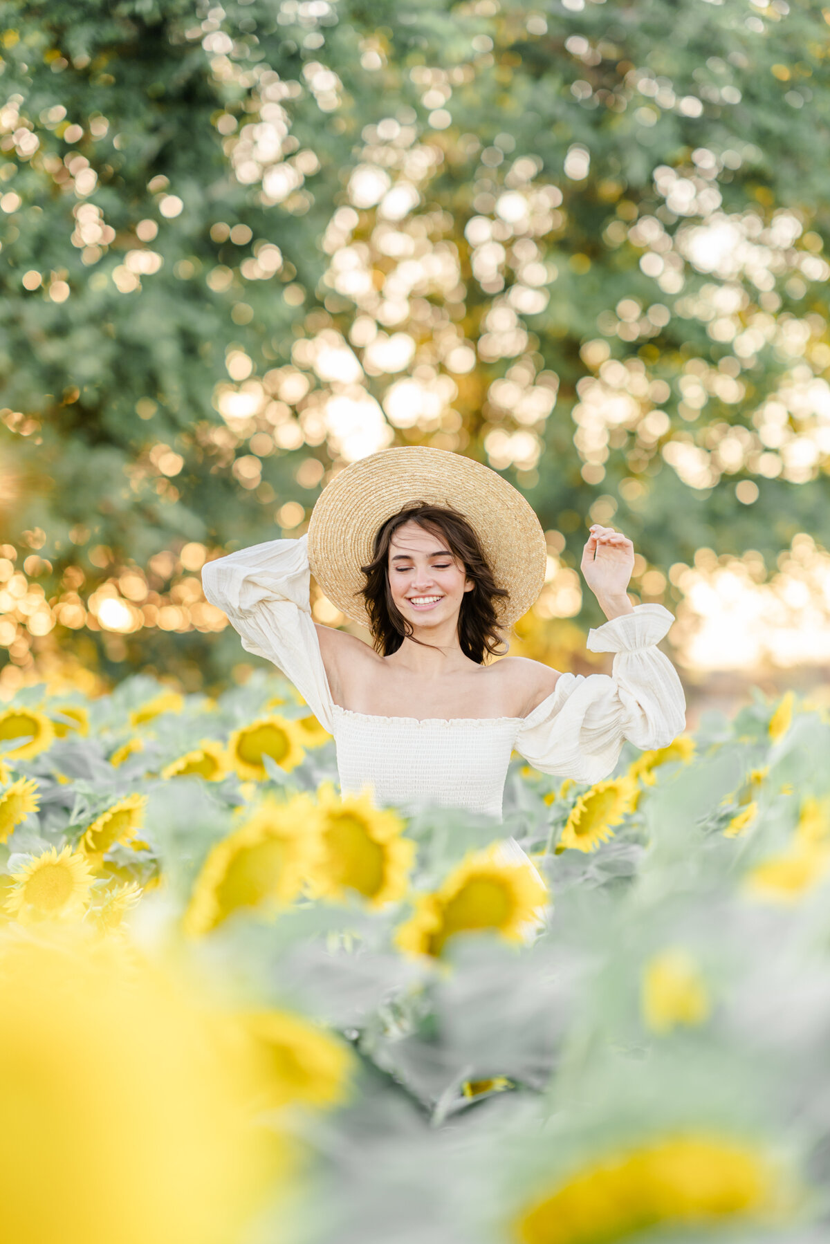 A portrait session photographed by Bay Area Photographer, Light Livin Photography shows a woman dancing in a field of sunflowers.