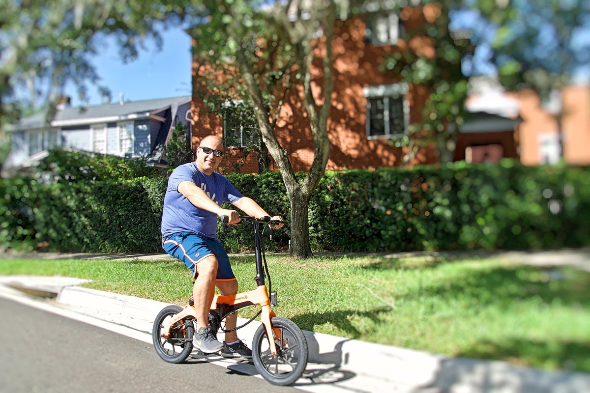 Man riding Orange Go-Bike M4 in his neighborhood