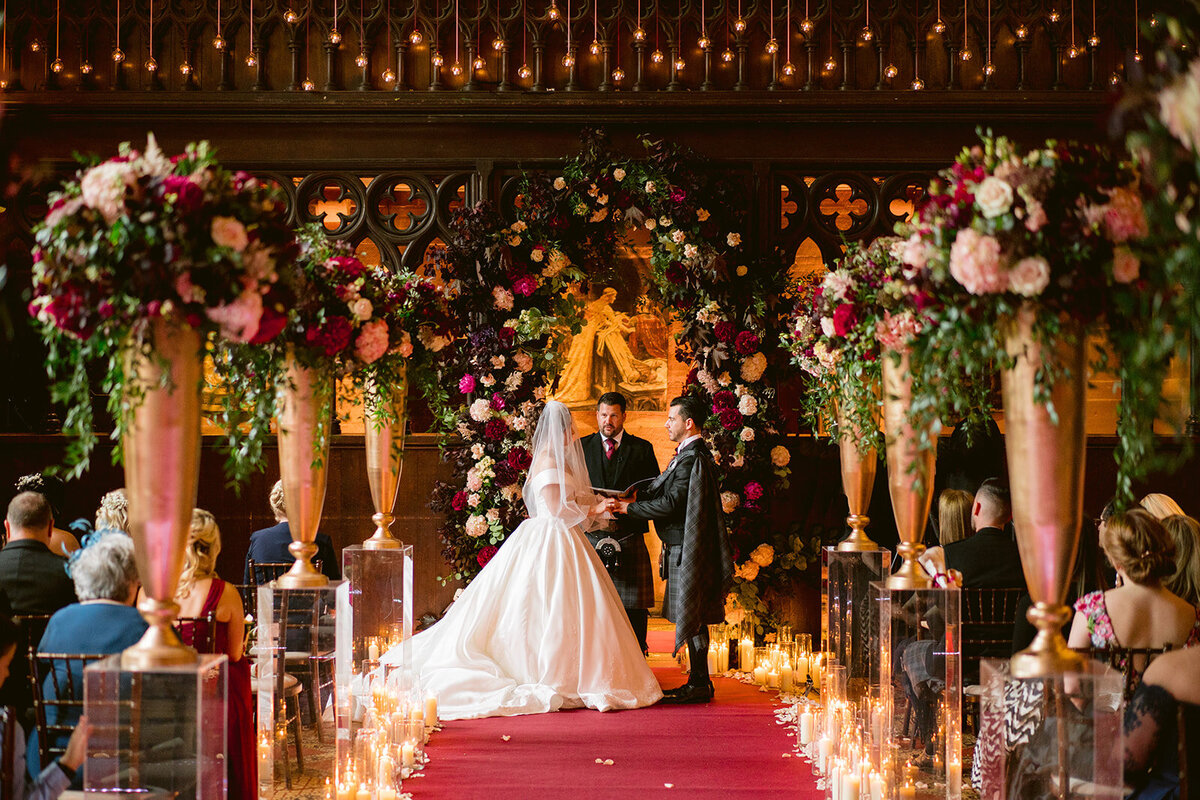 couple exchanging rings in the wedding ceremony at peckforton castle