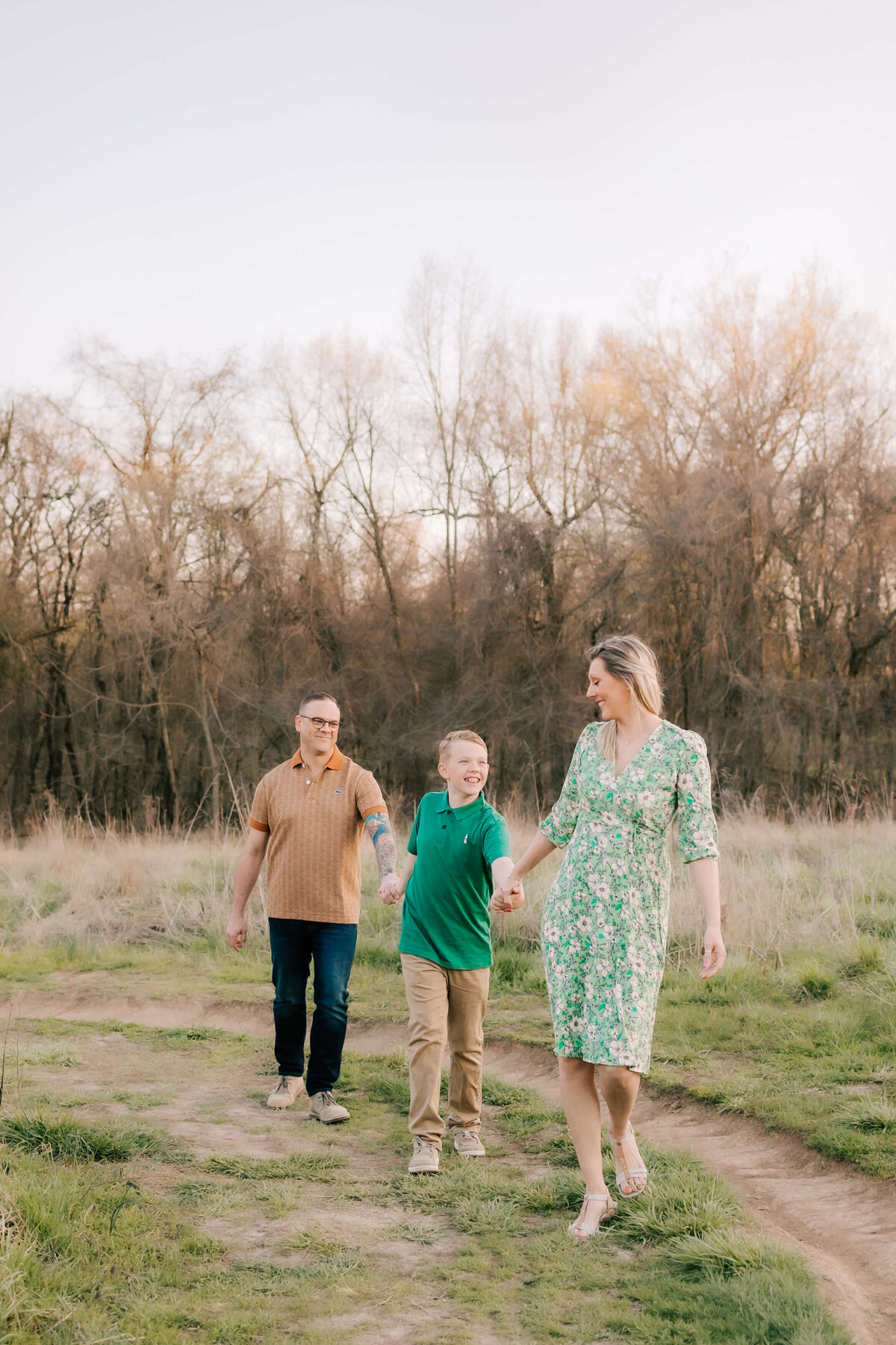 St. Louis family Photography featuring a gorgeous family of 3 walking hand in hand through the trails  in an Oakville Missouri park.