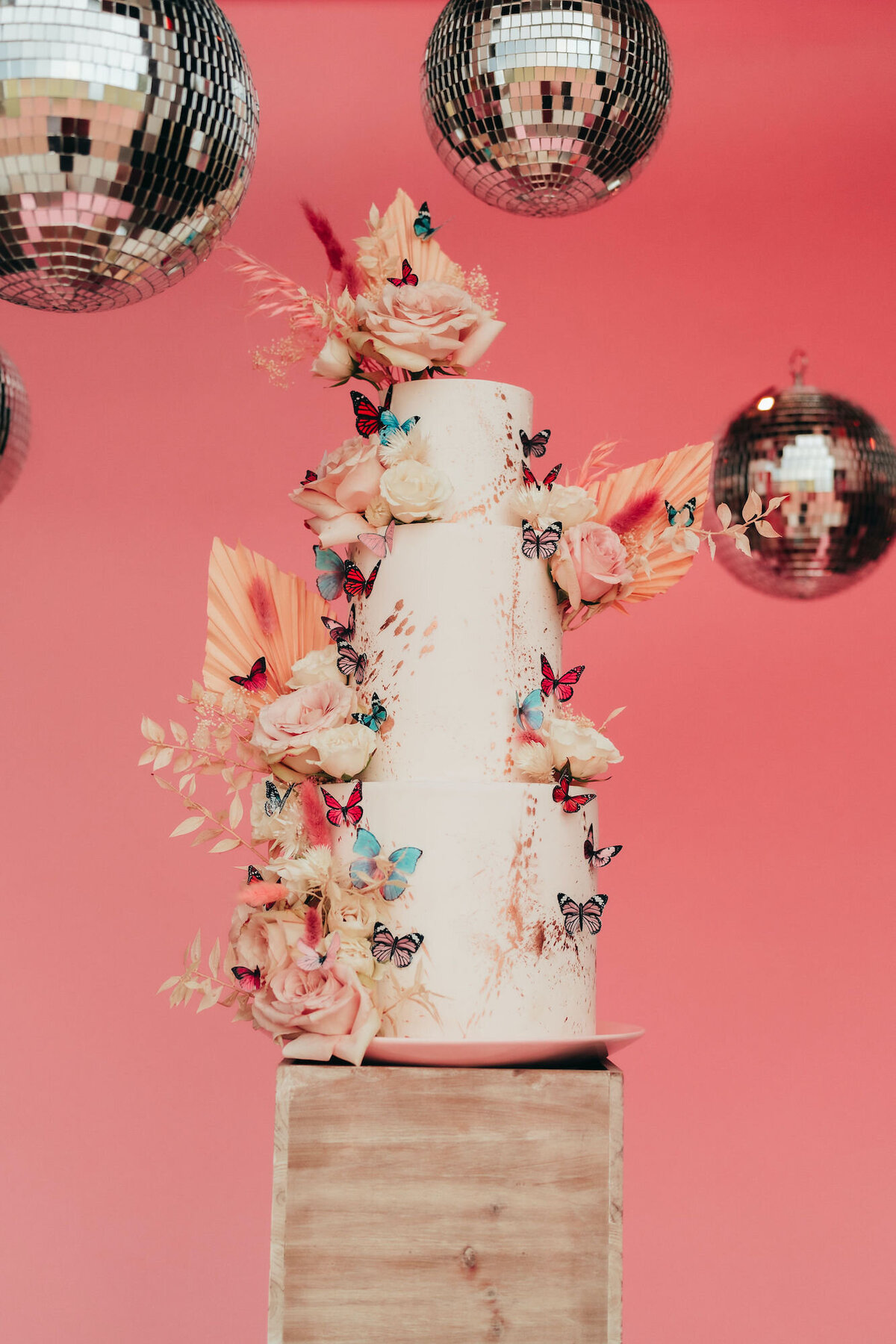wedding cake decorated with florals and butterflies