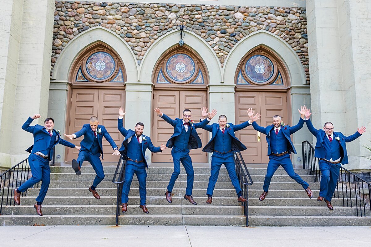 groom-and-groomsmen-jumping-off-steps-st-augustine-church