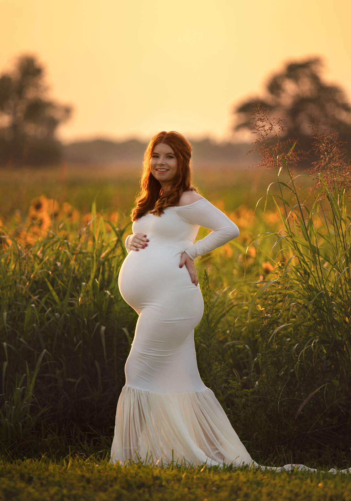 pregnant mom in white dress in sunflower field in st. louis