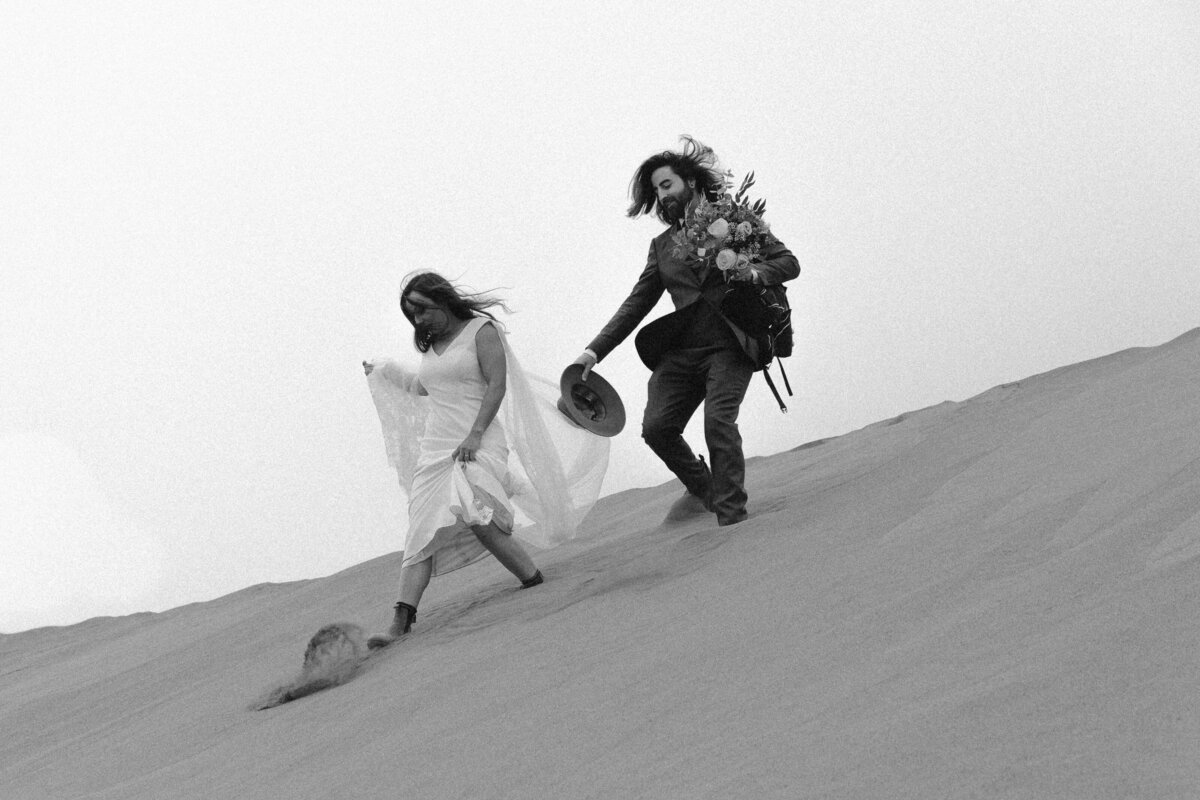 black and white image bride and groom on dunes