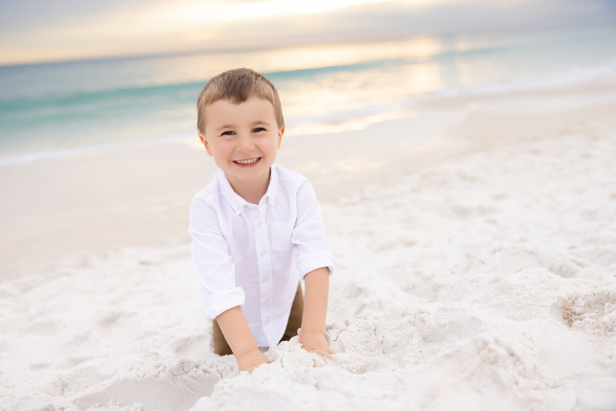 A small boy playing in the sand