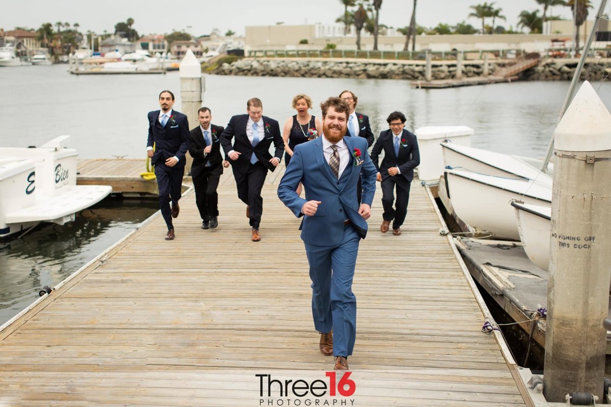 Groomsmen run up the boat ramp chasing the Groom as he tries to make a run for it