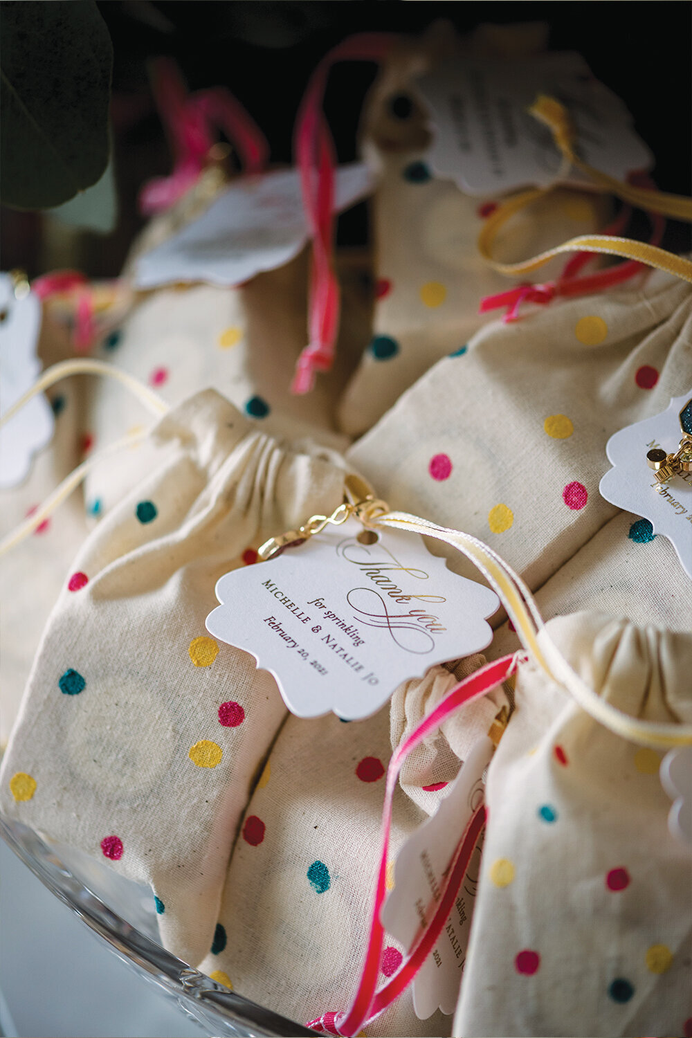 Scented shower steamers in custom polka dot bags with gold foil gift tags and crystal charms as elegant baby shower favors for a girl's celebration in Billings, MT.