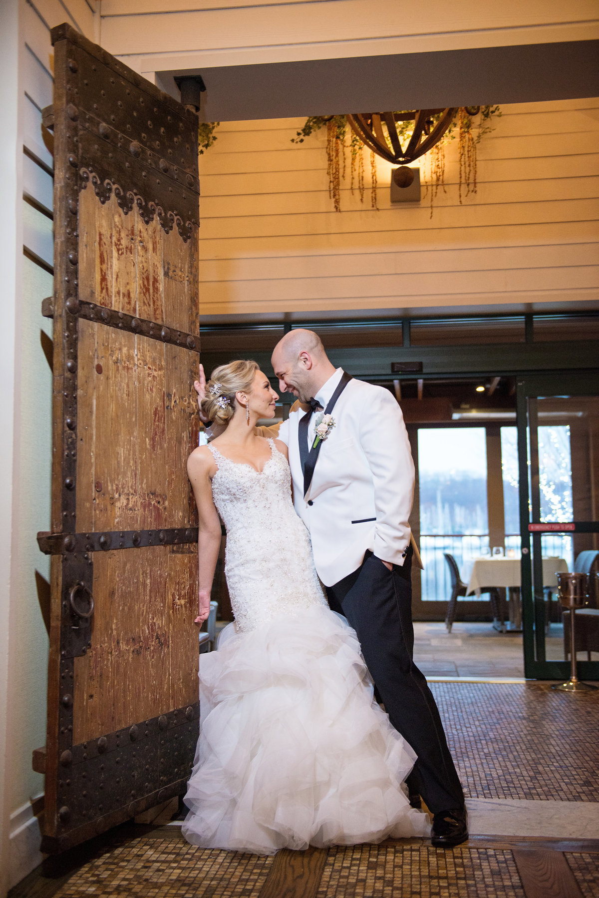 Bride and groom leaning on the door at Prime
