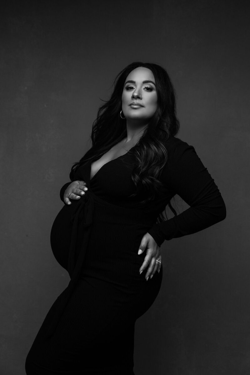 Pregnant woman wearing black posing for new jersey maternity photographer