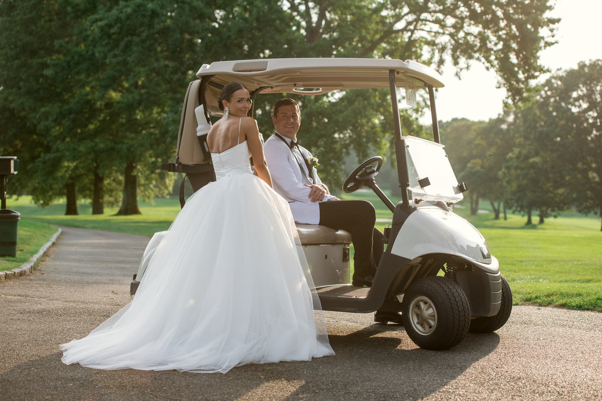 bride and groom on golf cart outside The Muttontown Club