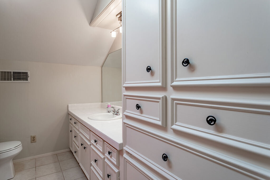 Bathroom with large vanity and plenty of cabinet space in this 5-bedroom, 4-bathroom vacation rental house for 16+ guests with pool, free wifi, guesthouse and game room just 20 minutes away from downtown Waco, TX.