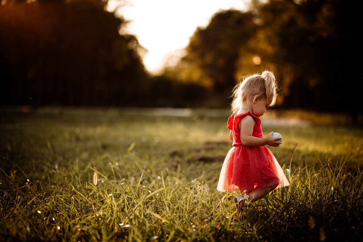 Little Girl Walking In The Field At Sunset