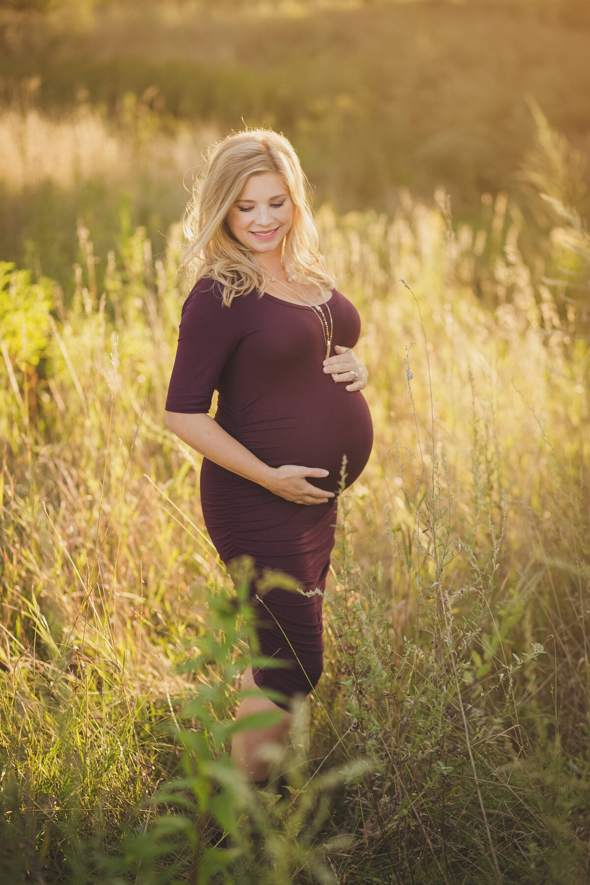 pregnant woman in field in purple dress