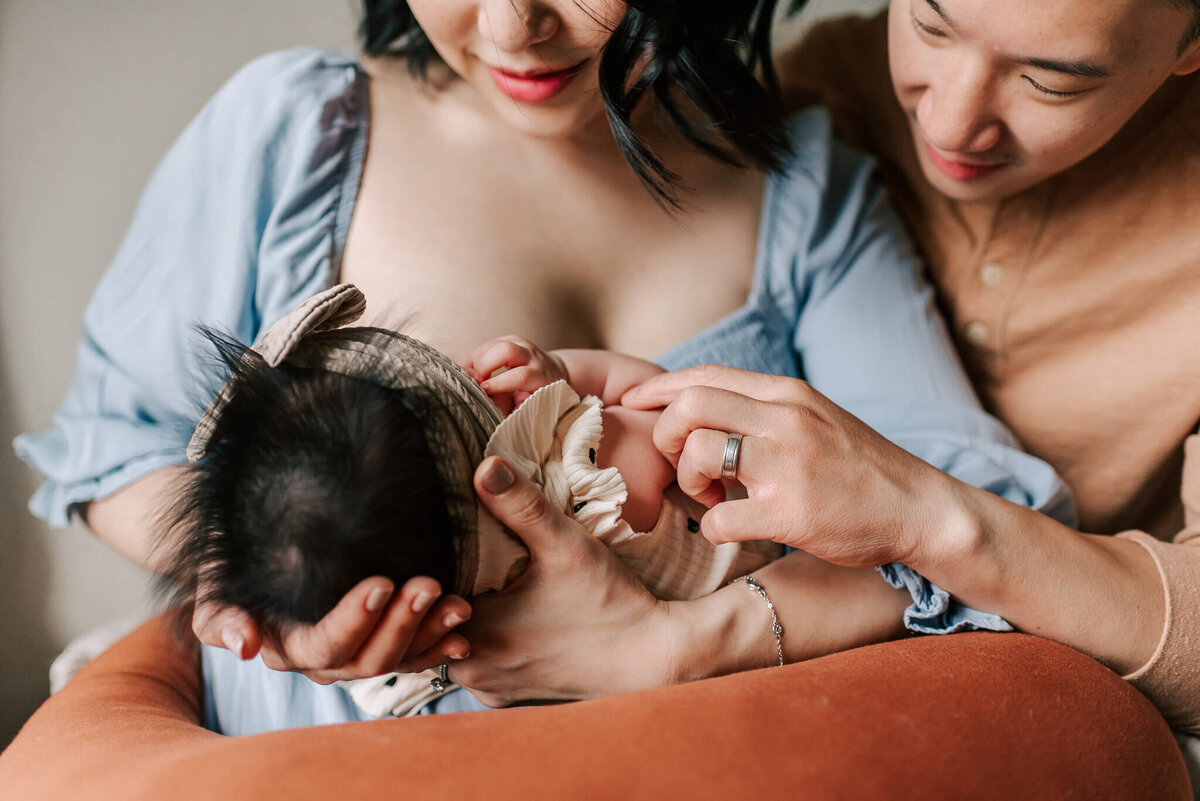 Parents gazing sweetly at their nursing baby, taken by a northern virginia newborn photographer