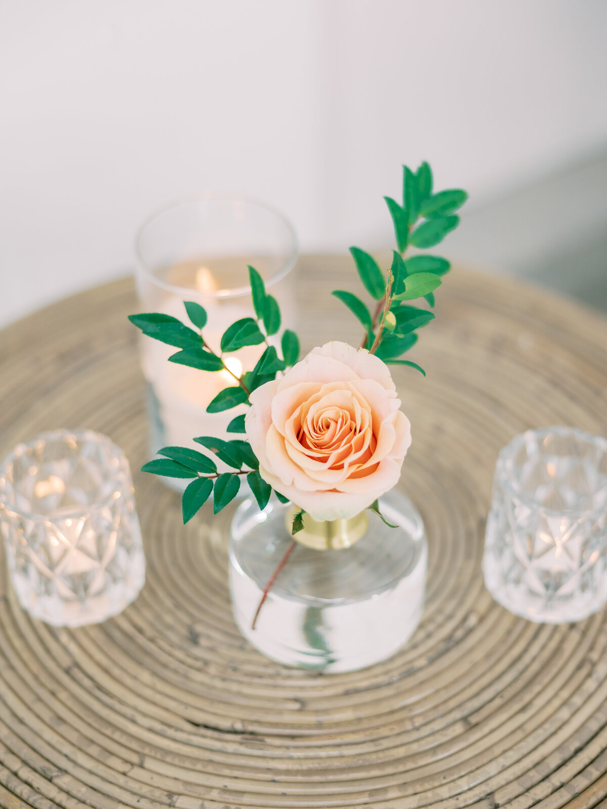 Small vases with simple floral designs and candles.